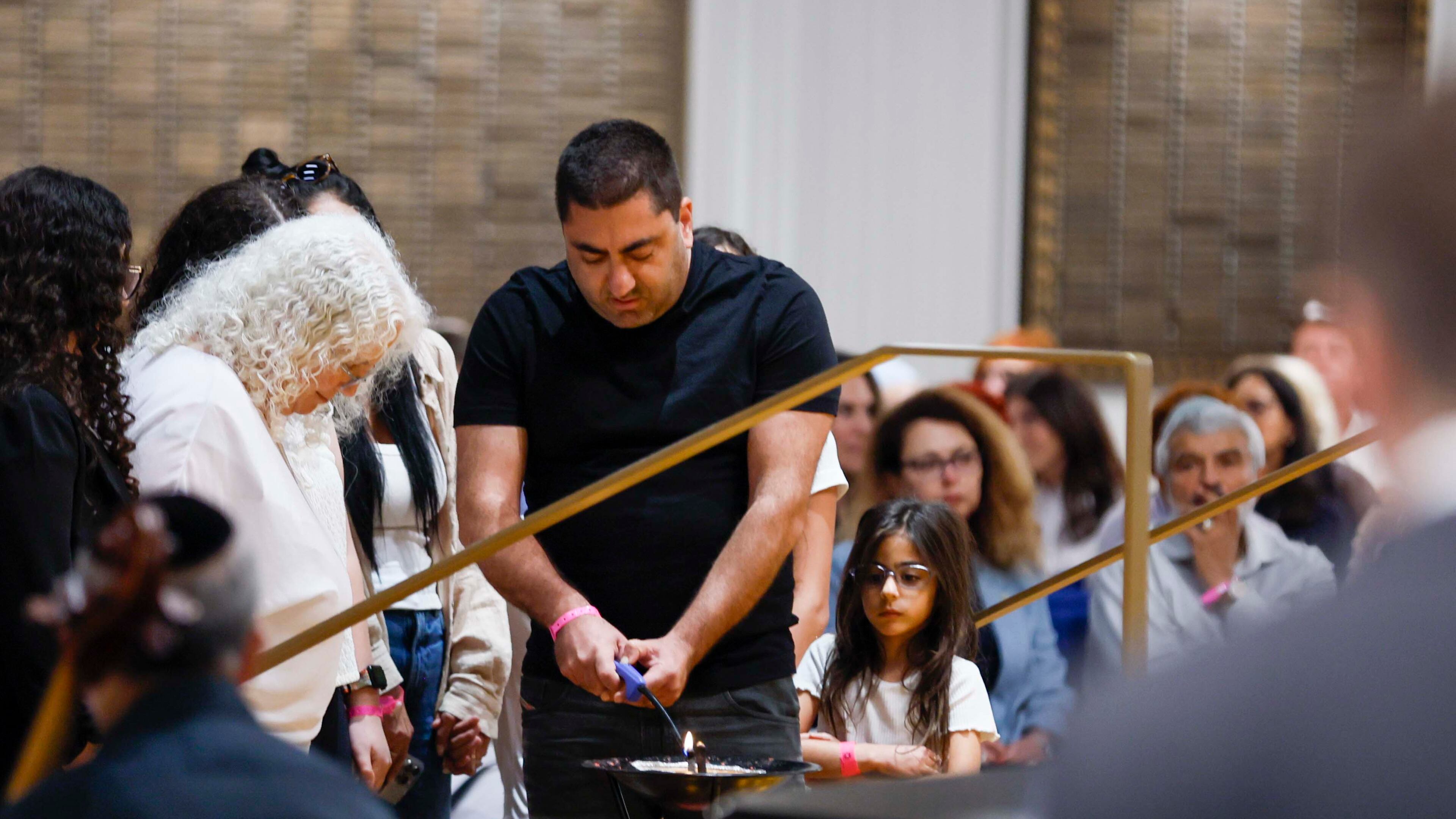 Members of the Jewish community participate in lighting a memorial ritual honoring victims at the Ahavath Achim Synagogue as members of the Jewish community gathered on Sunday, Oct. 5, 2025, to commemorate the second anniversary of the Oct. 7 attacks.
(Miguel Martinez/AJC)