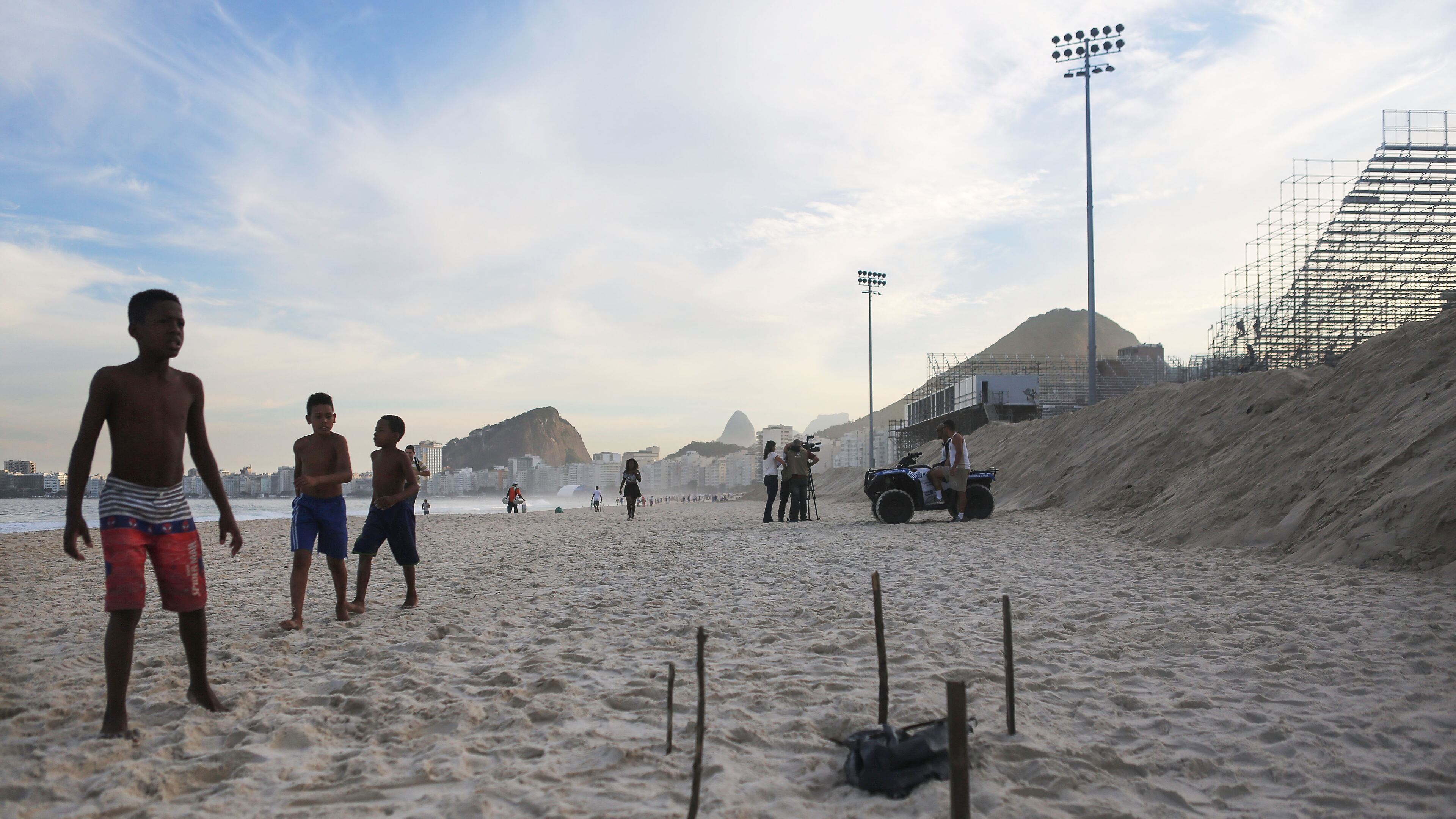 RIO DE JANEIRO, BRAZIL - JUNE 29: Young beachgoers walk near a body part, covered in a plastic bag, which was discovered on Copacabana Beach near the Olympic beach volleyball venue (TOP R) on June 29, 2016 in Rio de Janeiro, Brazil. Parts of a mutilated body were discovered on the sands of the beach while it remains unknown how the person died. The Rio 2016 Olympic Games begin August 5 amidst an economic crisis in the country. (Photo by Mario Tama/Getty Images)