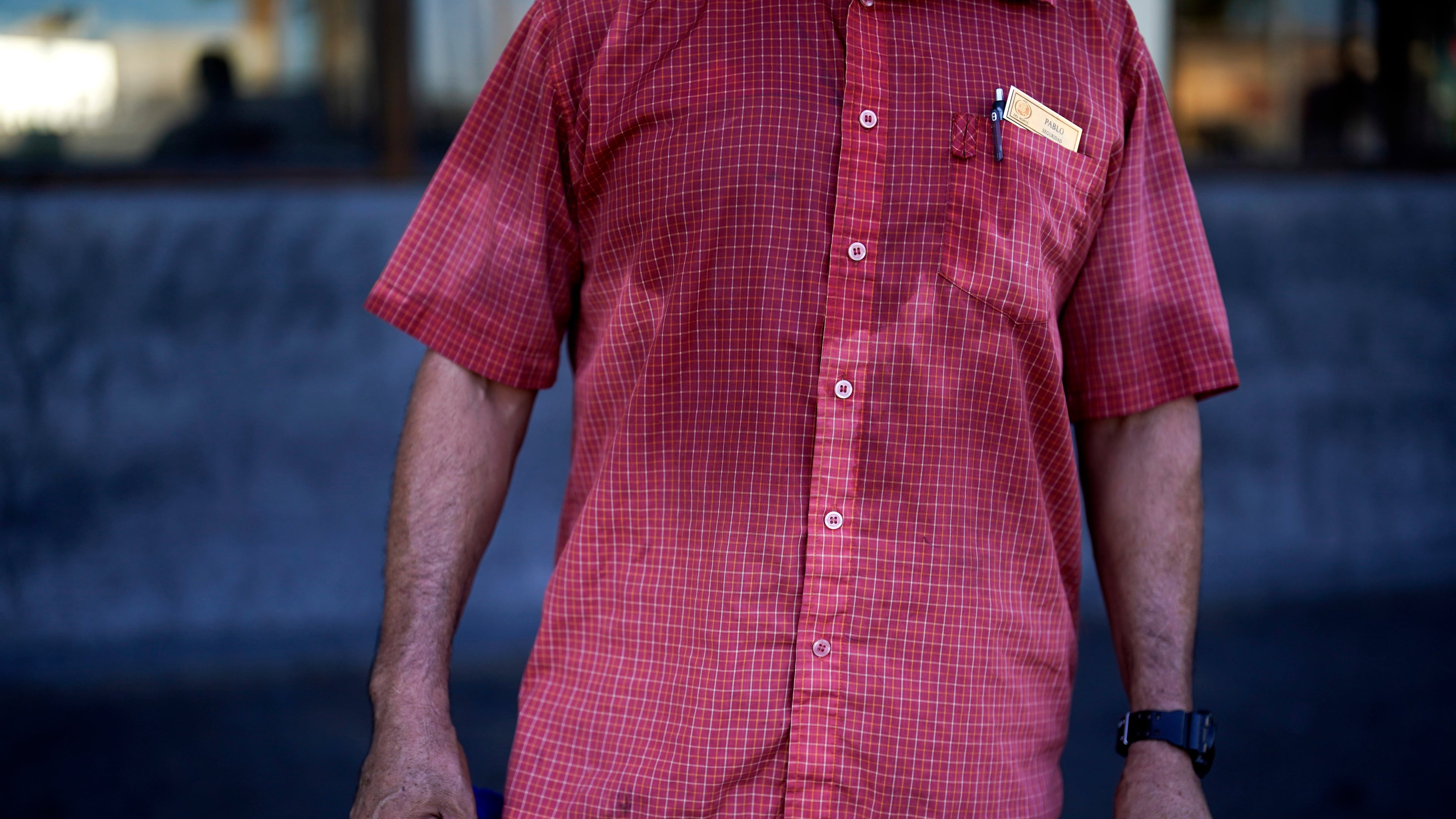 FILE - A man's shirt is bathed in sweat before seven in the morning as he parks cars and provides security for a downtown cafe July 20, 2023, in Mexicali, Mexico. (AP Photo/Gregory Bull, File)