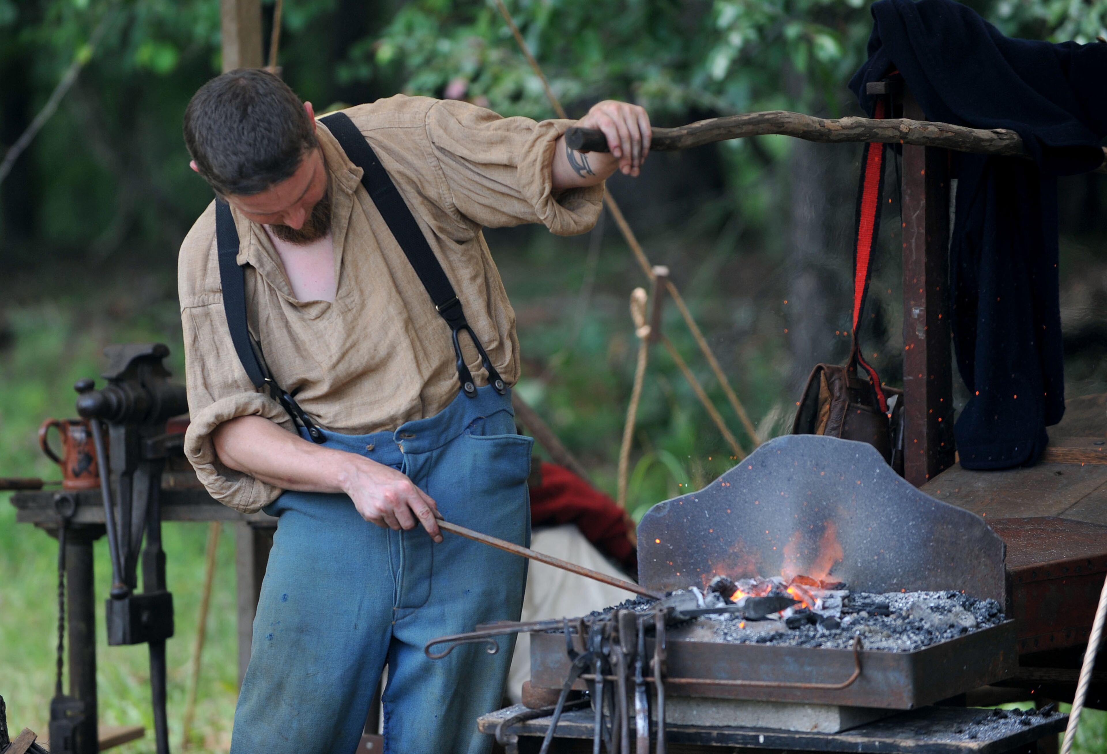 Blacksmith John Scroggin of Roswell demonstrates his craft in the Union encampment Friday, June 27, 2014.