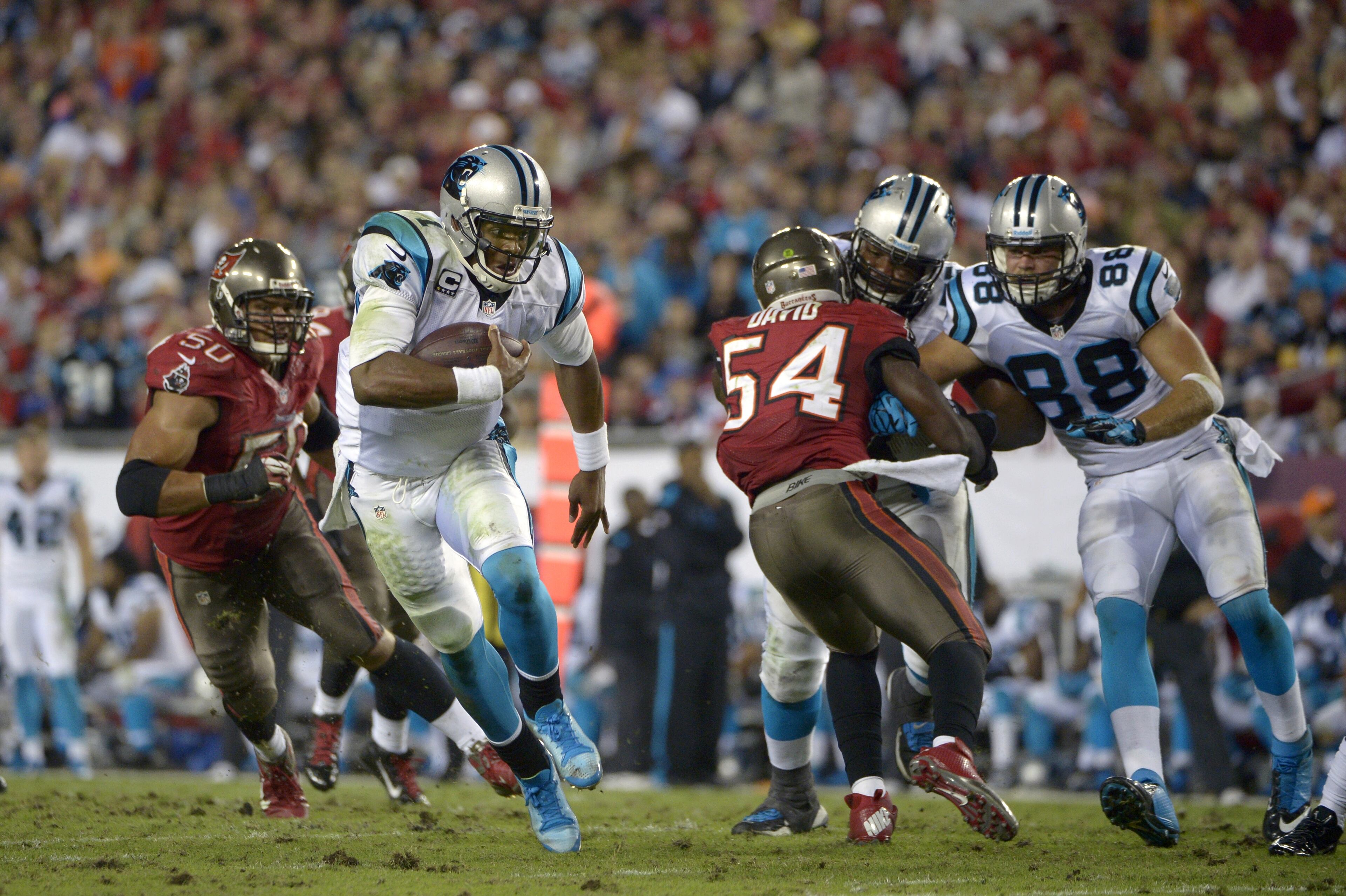 Carolina Panthers quarterback Cam Newton (1) rushes for yardage past Tampa Bay Buccaneers defensive end Daniel Te'o-Nesheim (50) and outside linebacker Lavonte David (54) during the second half of an NFL football game in Tampa, Fla., on Thursday, Oct. 24, 2013. The Carolina Panthers beat the Tampa Bay Buccaneers 31-13. (AP Photo/Phelan M. Ebenhack)