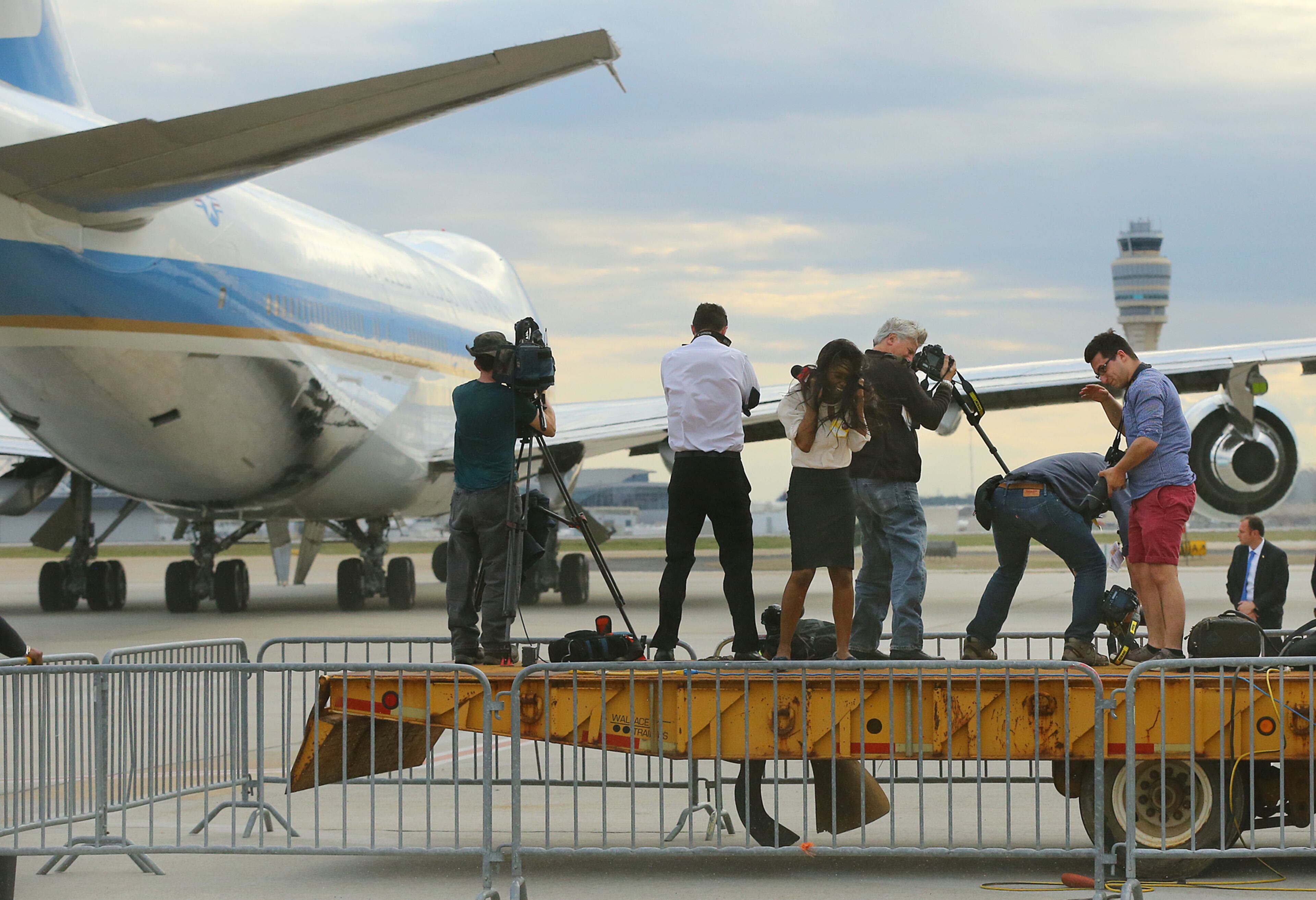 Members of the local news media on a platform are blasted by the jet wash while covering Air Force One leaving with President Barack Obama after his visit on Tuesday, March 10, 2015, in Atlanta. Curtis Compton / ccompton@ajc.com
