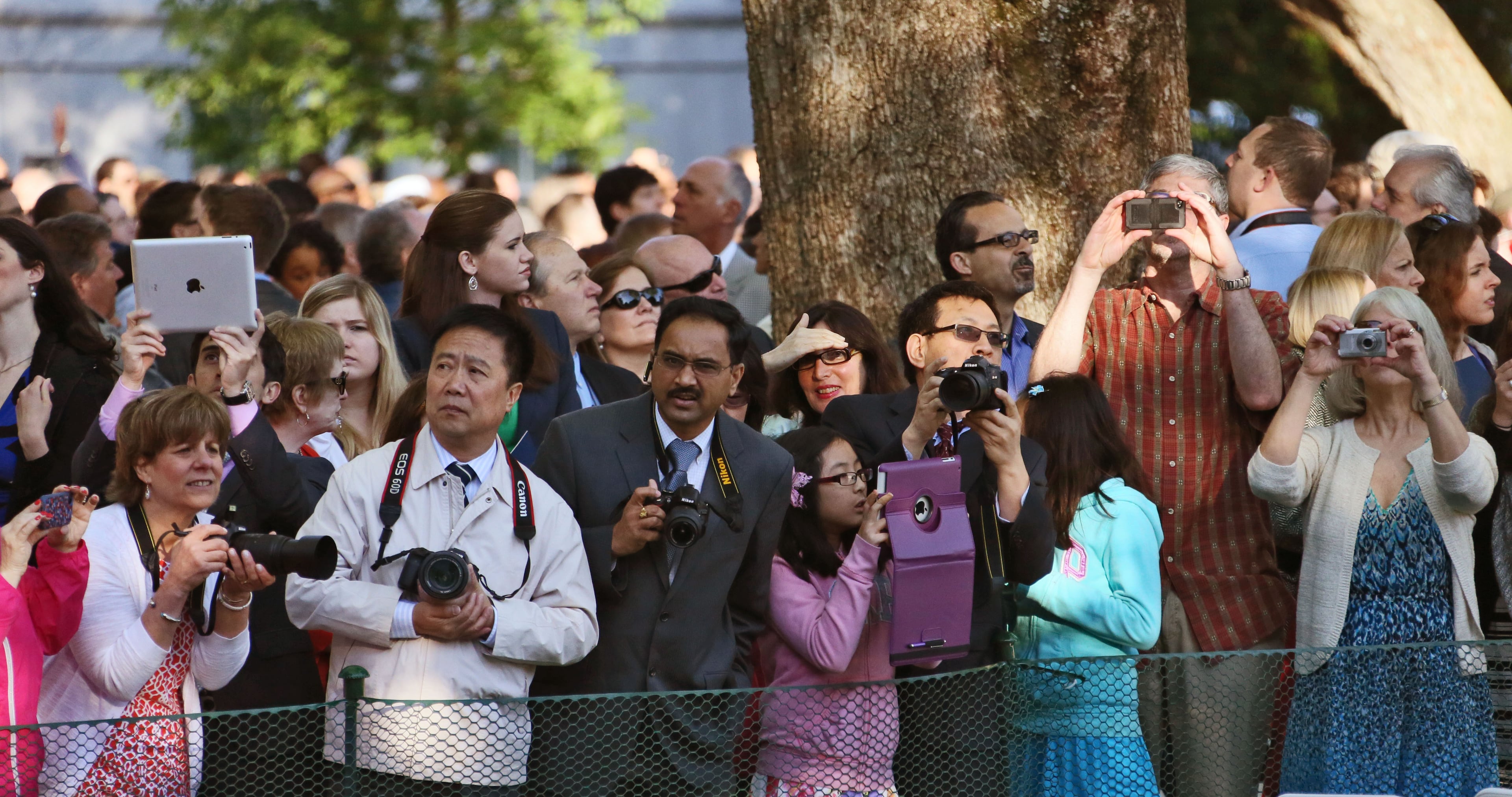 Family members and friends of graduates strain for a look as the students walk in for graduation.