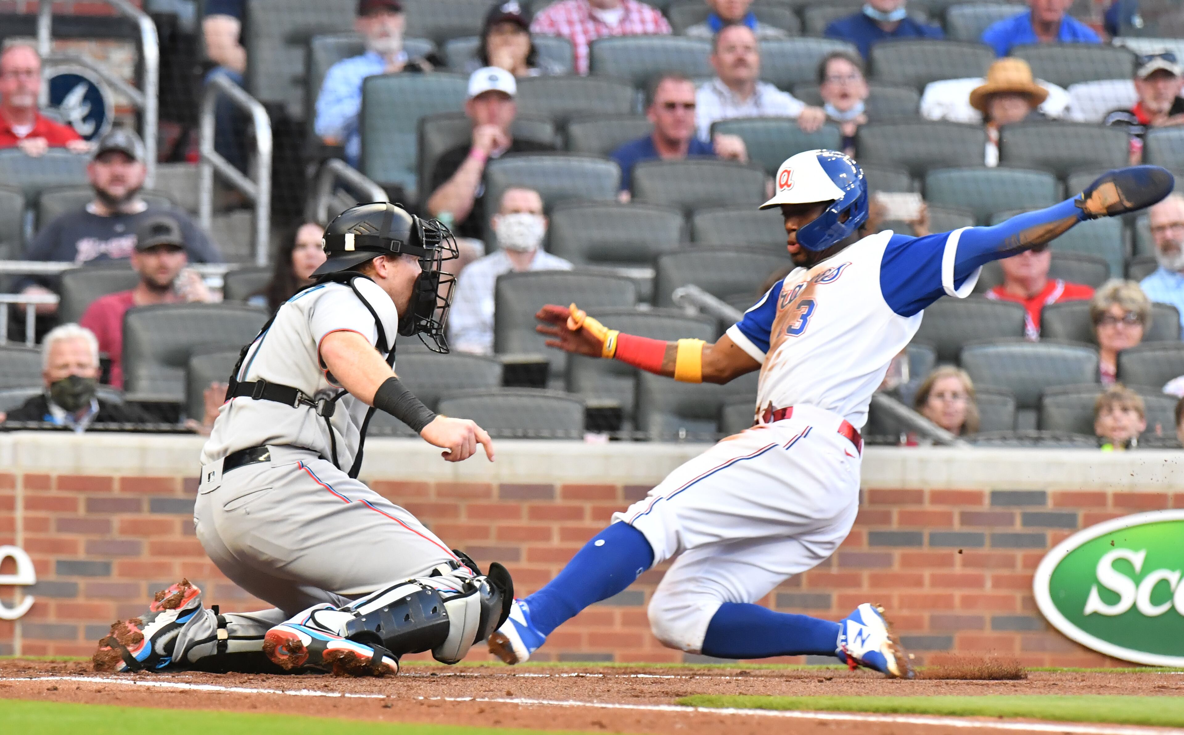 April 12, 2021 Atlanta - Atlanta Braves right fielder Ronald Acuna Jr. (13) scores past Miami Marlins catcher Chad Wallach (17) on an RBI single by Atlanta Braves left fielder Marcell Ozuna (20) in the first inning at Truist Park on Monday, April 12, 2021. (Hyosub Shin / Hyosub.Shin@ajc.com)