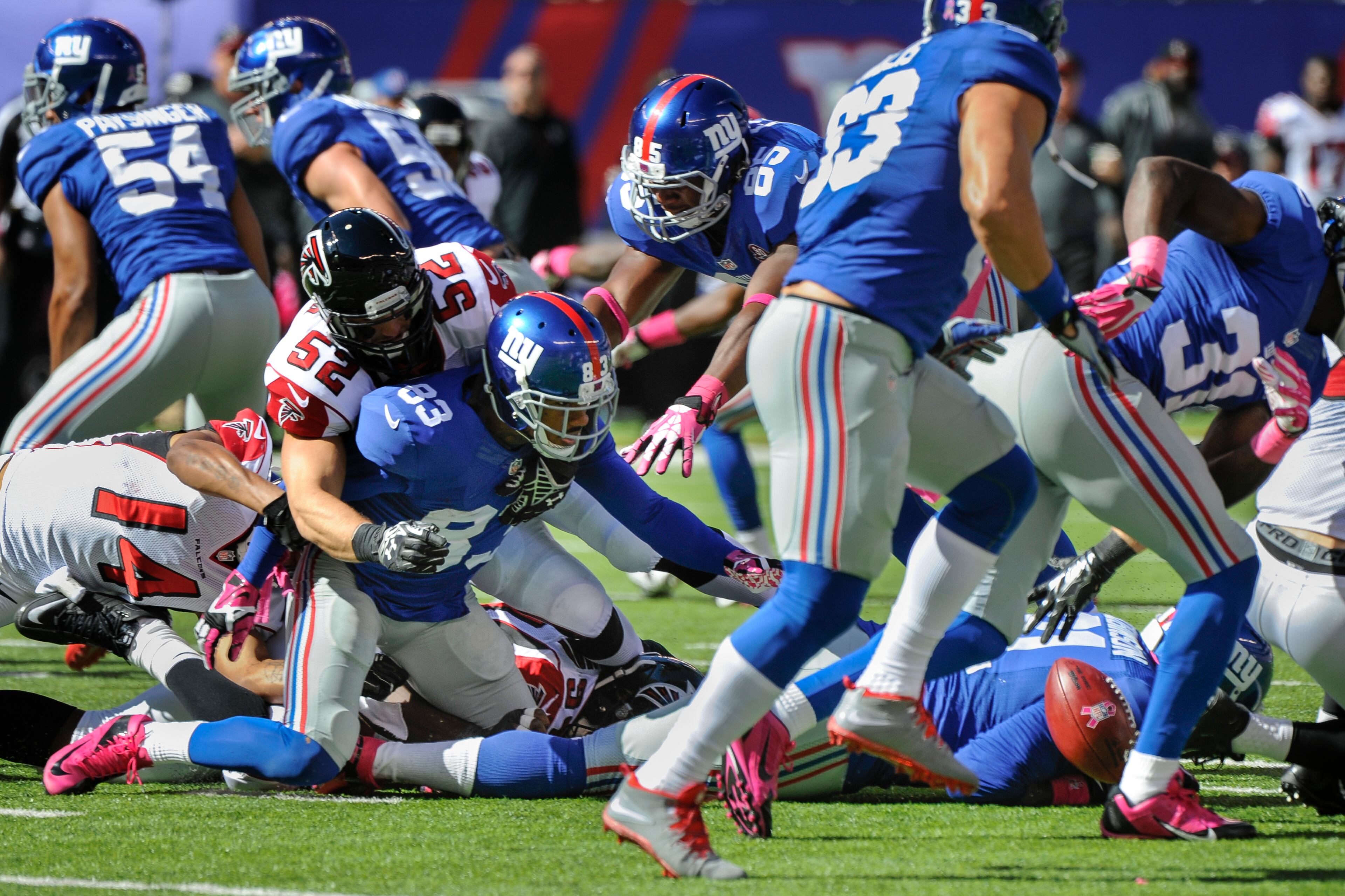 New York Giants wide receiver Preston Parker (83) fumbles a kickoff return while Atlanta Falcons linebacker Nate Stupar (52) makes the hit during the first half of an NFL football game, Sunday, Oct. 5, 2014, in East Rutherford, N.J. (AP Photo/Bill Kostroun)