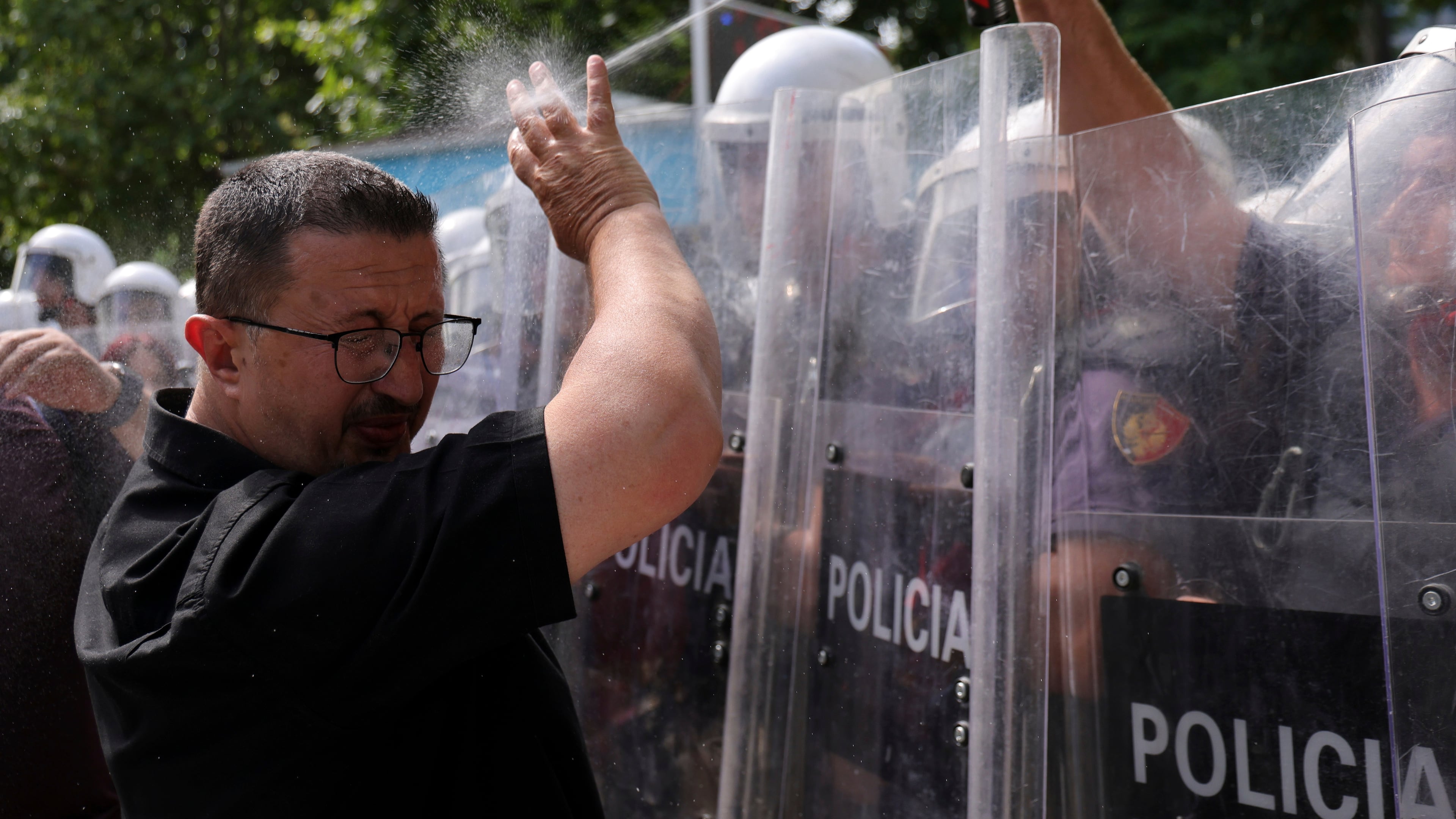 A riot police officer uses pepper spray against a protester during clashes at an anti-government rally in Tirana, Albania, Thursday, July 2, 2026. (AP Photo/Hameraldi Agolli)
