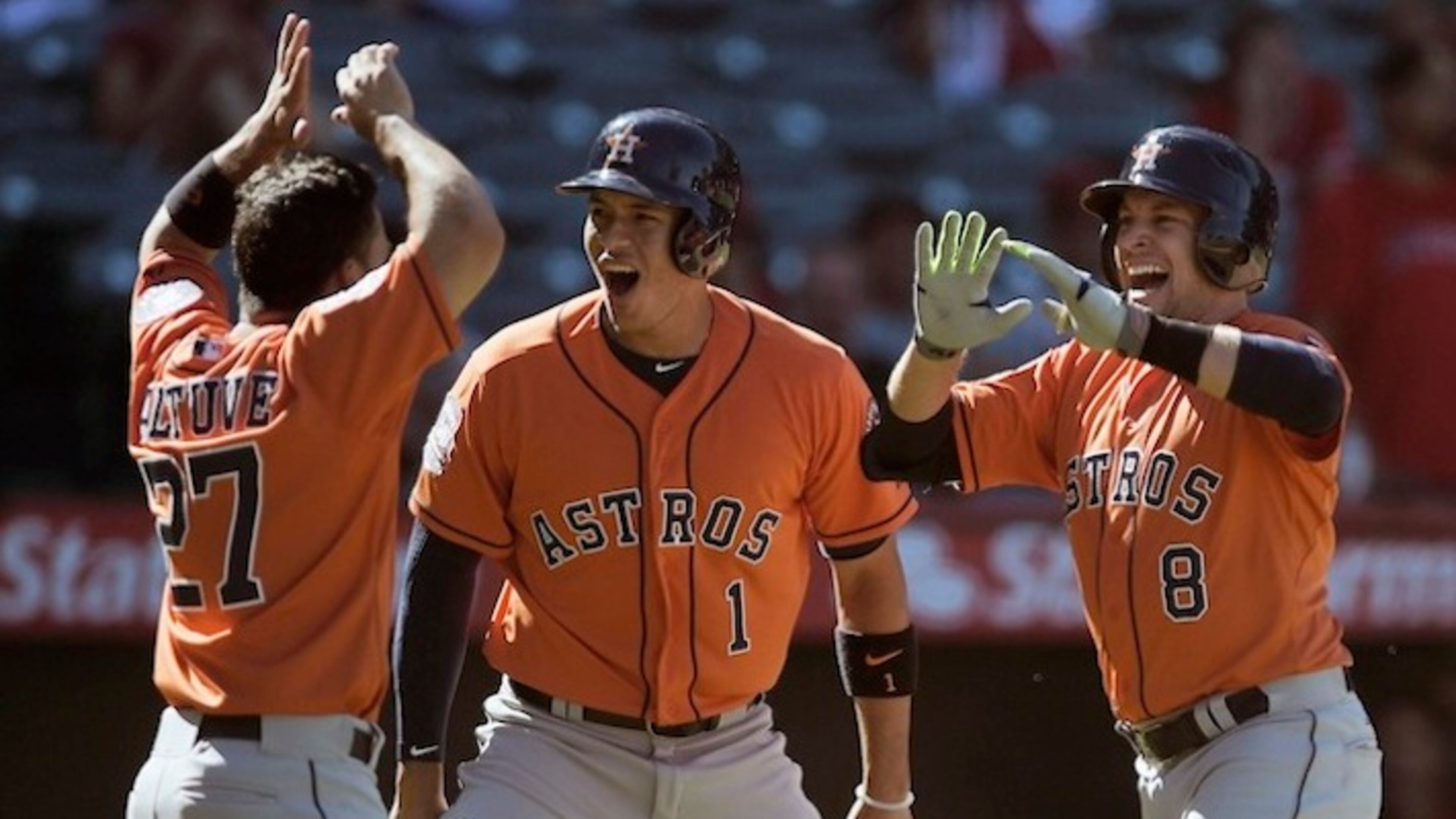 Houston Astros' Jed Lowrie, right, celebrates with Carlos Correa, center, and Jose Altuve, left, after hitting the go-ahead three-run home run off Los Angeles Angels relief pitcher Huston Street during the ninth inning of a baseball game in Anaheim, Calif., Sunday, Sept. 13, 2015. (AP Photo/Kelvin Kuo)