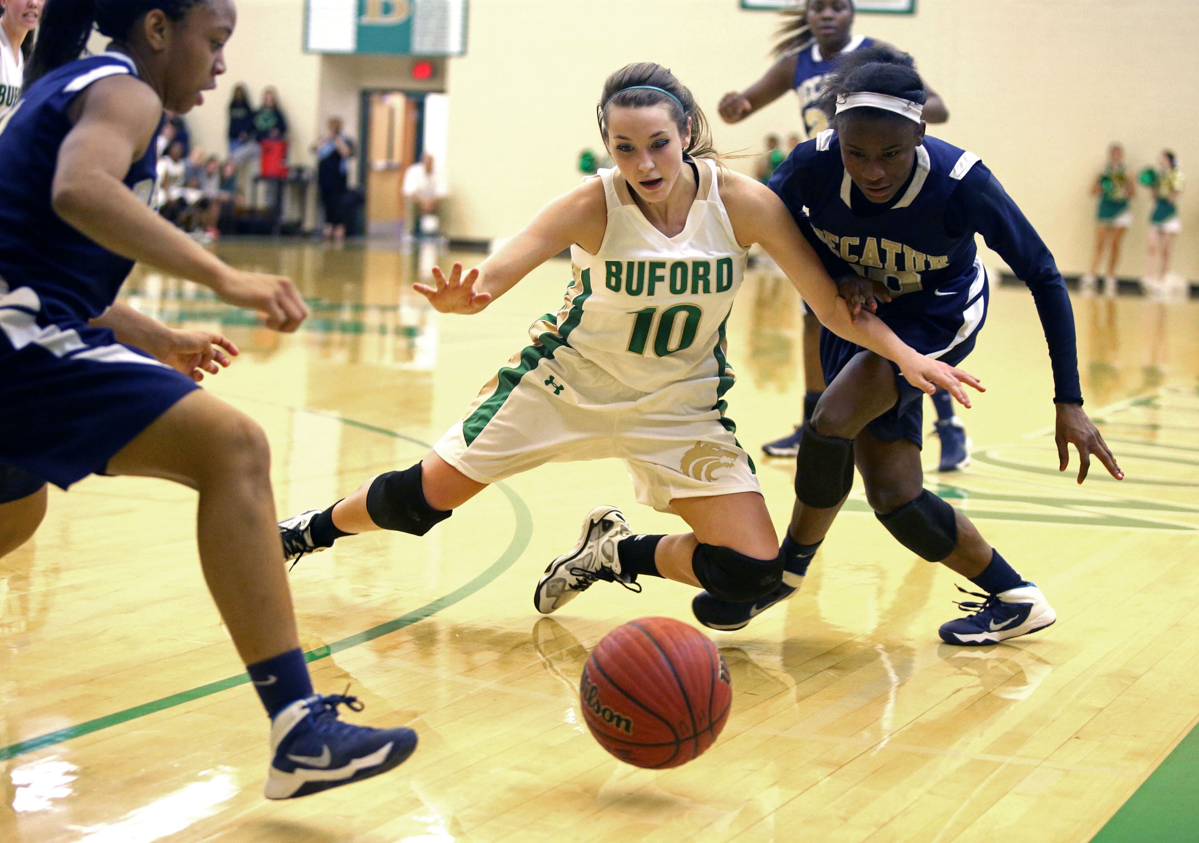 Buford's Taylor Ozment (10, center) fights for a loose ball with Decatur's Jahmee Reeves, right, and Jayla Morrow, left. Buford defeated Decatur 41-28 in the second round of the Class AAA state basketball tournament. JASON GETZ / SPECIAL