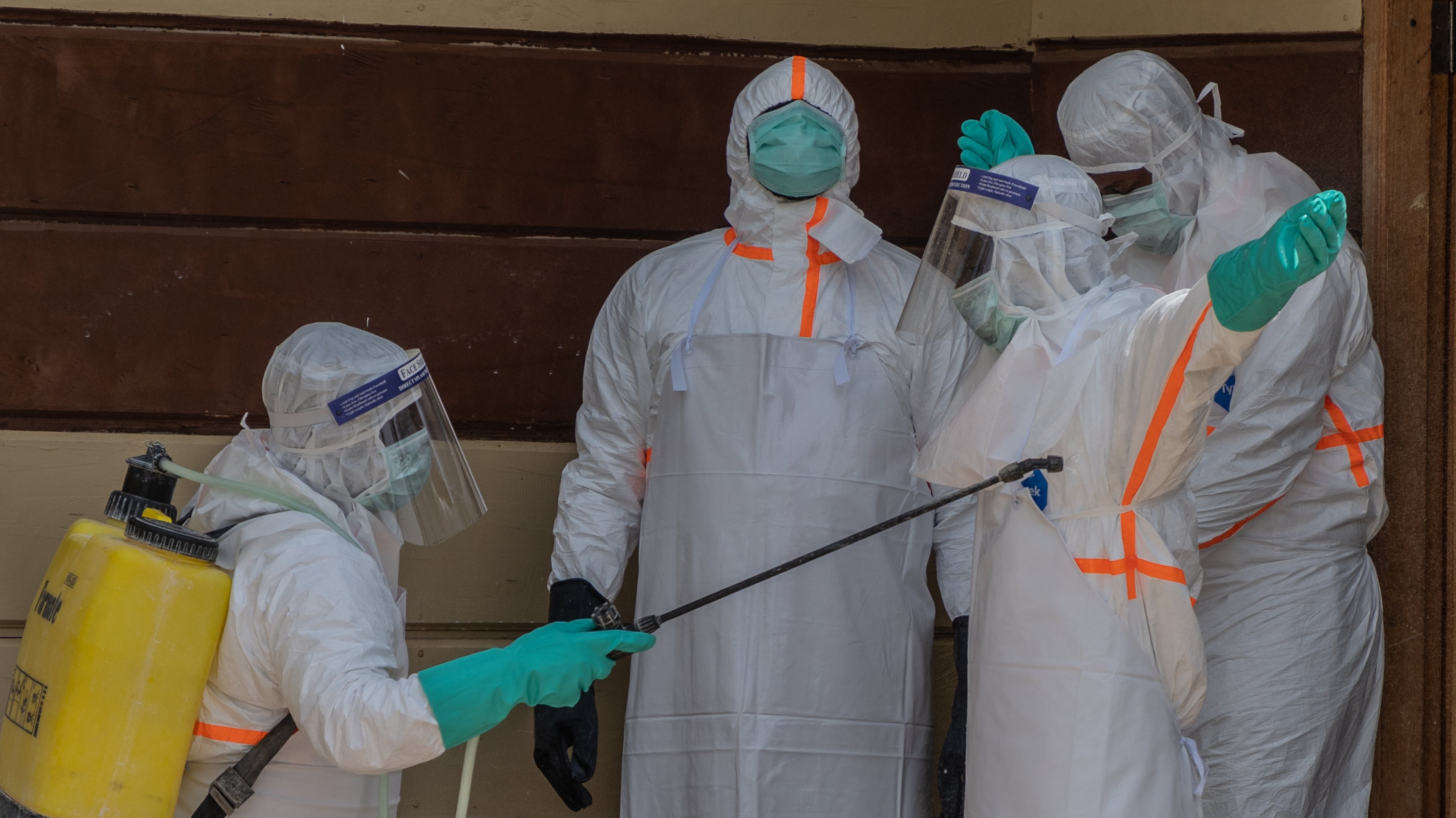 Health workers disinfect themselves after preparing the body of an Ebola victim at Citadelle Clinic in Bunia, Congo, Friday, June 12, 2026. (AP Photo/Moses Sawasawa)