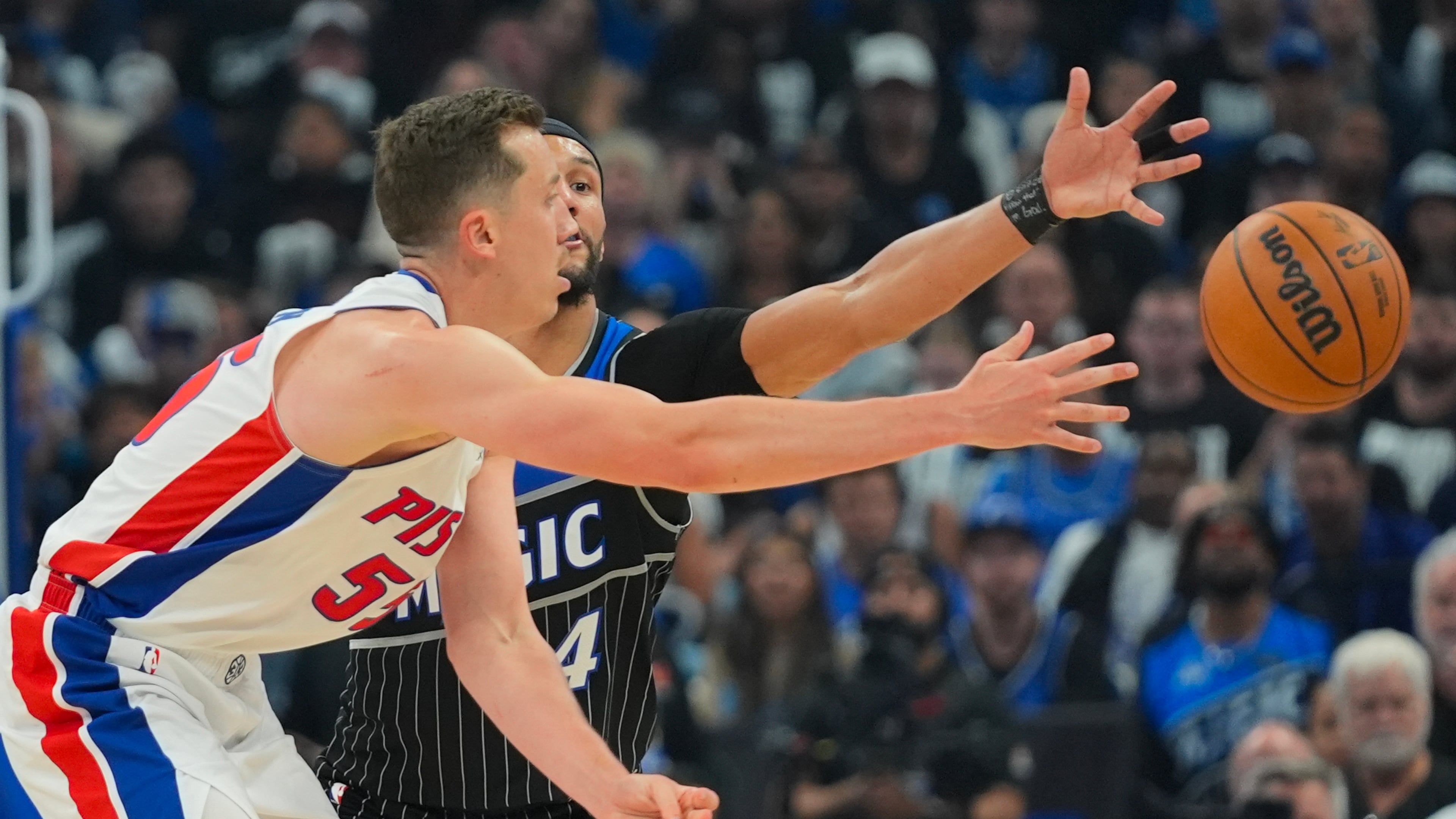 Detroit Pistons forward Duncan Robinson, left, passes the ball against Orlando Magic guard Jalen Suggs (4) during the second half in Game 6 of a first-round NBA basketball playoffs series, Friday, May 1, 2026, in Orlando, Fla. (AP Photo/John Raoux)