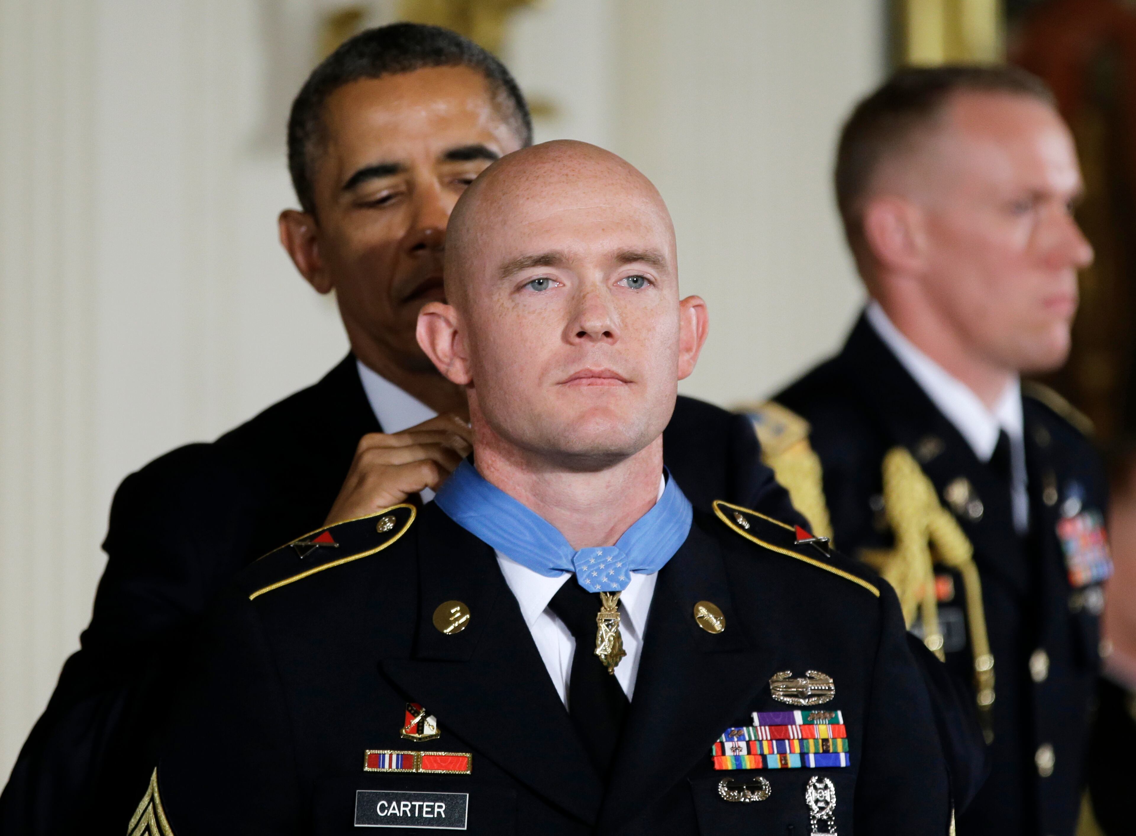 President Barack Obama awards US Army Staff Sgt. Ty M. Carter the Medal of Honor for conspicuous gallantry, Monday, Aug. 26, 2013, during a ceremony in the East Room of the White House in Washington. Carter received the medal for his courageous actions while serving as a cavalry scout with Bravo Troop, 3rd Squadron, 61st Cavalry Regiment, 4th Brigade Combat Team, 4th Infantry Division, during combat operations in Kamdesh District, Nuristan Province, Afghanistan on Oct. 3, 2009. Carter is the fifth living recipient to be awarded the Medal of Honor for actions in Iraq or Afghanistan. (AP Photo/Carolyn Kaster)