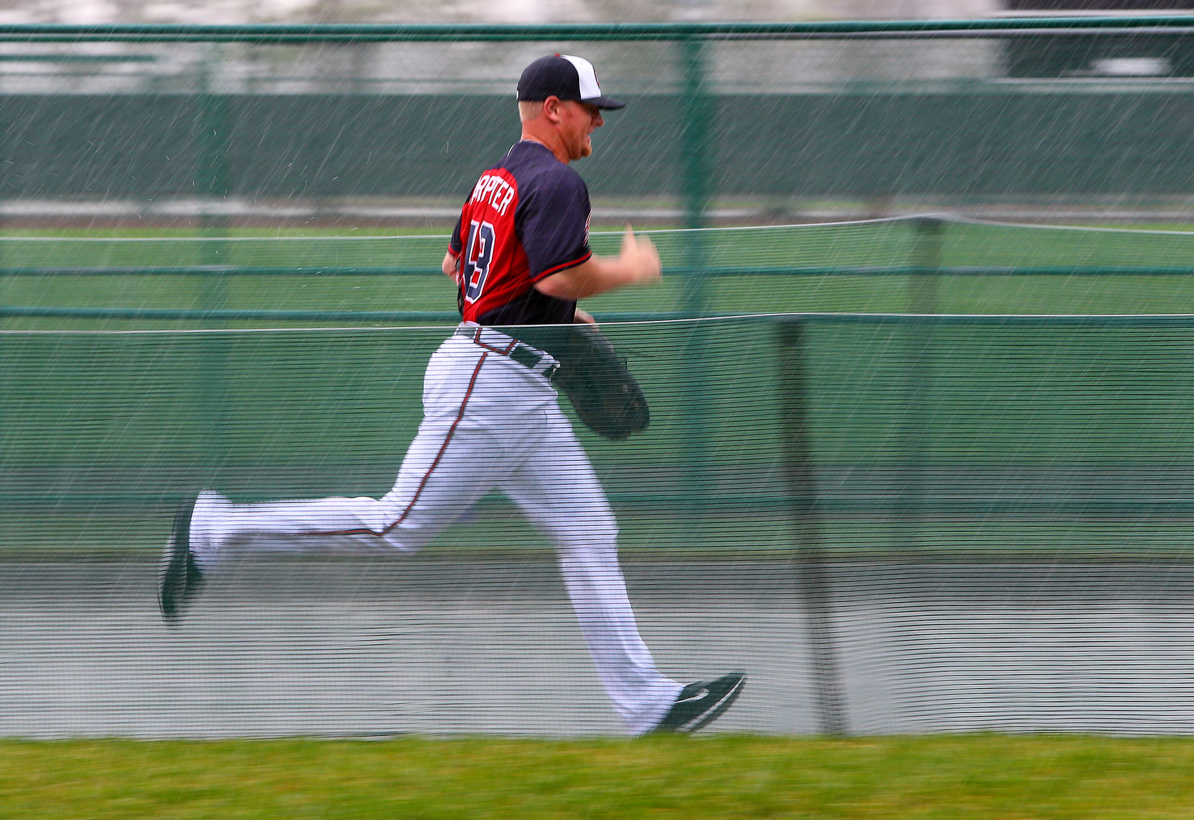 Braves pitcher David Carpenter runs for cover during a rainy day of spring training practice on Friday, Feb. 21, 2014, in Lake Buena Vista, FL. Due to inclement weather all players, coaches, and fans were asked to clear the fields as thunder storms moved through the area forcing players into the batting tunnels for the day.