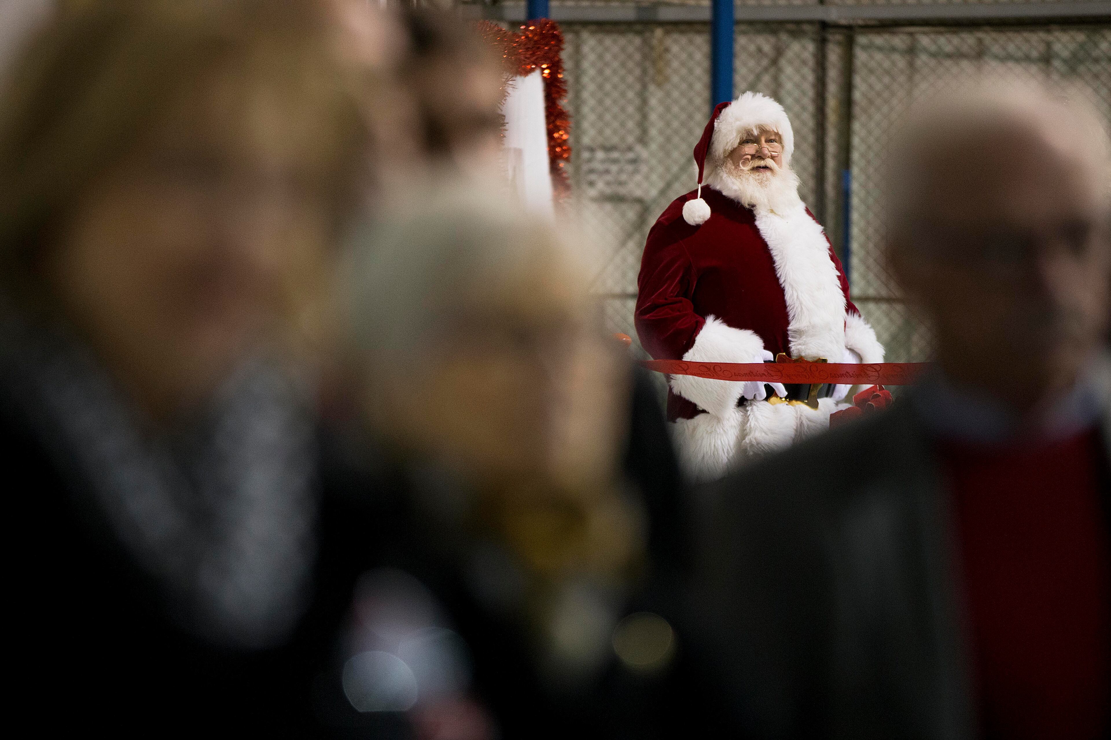 Santa Claus waits with audience members before Republican presidential candidate, Sen. Ted Cruz, R-Texas, arrives for a campaign event Friday, Dec. 18, 2015, in Kennesaw, Ga. Cruz is on an eight-state, 12-city "Christmas Tour," and at each stop, the campaign plans to have Santa Claus on hand, posing for pictures and kissing babies. (AP Photo/David Goldman)