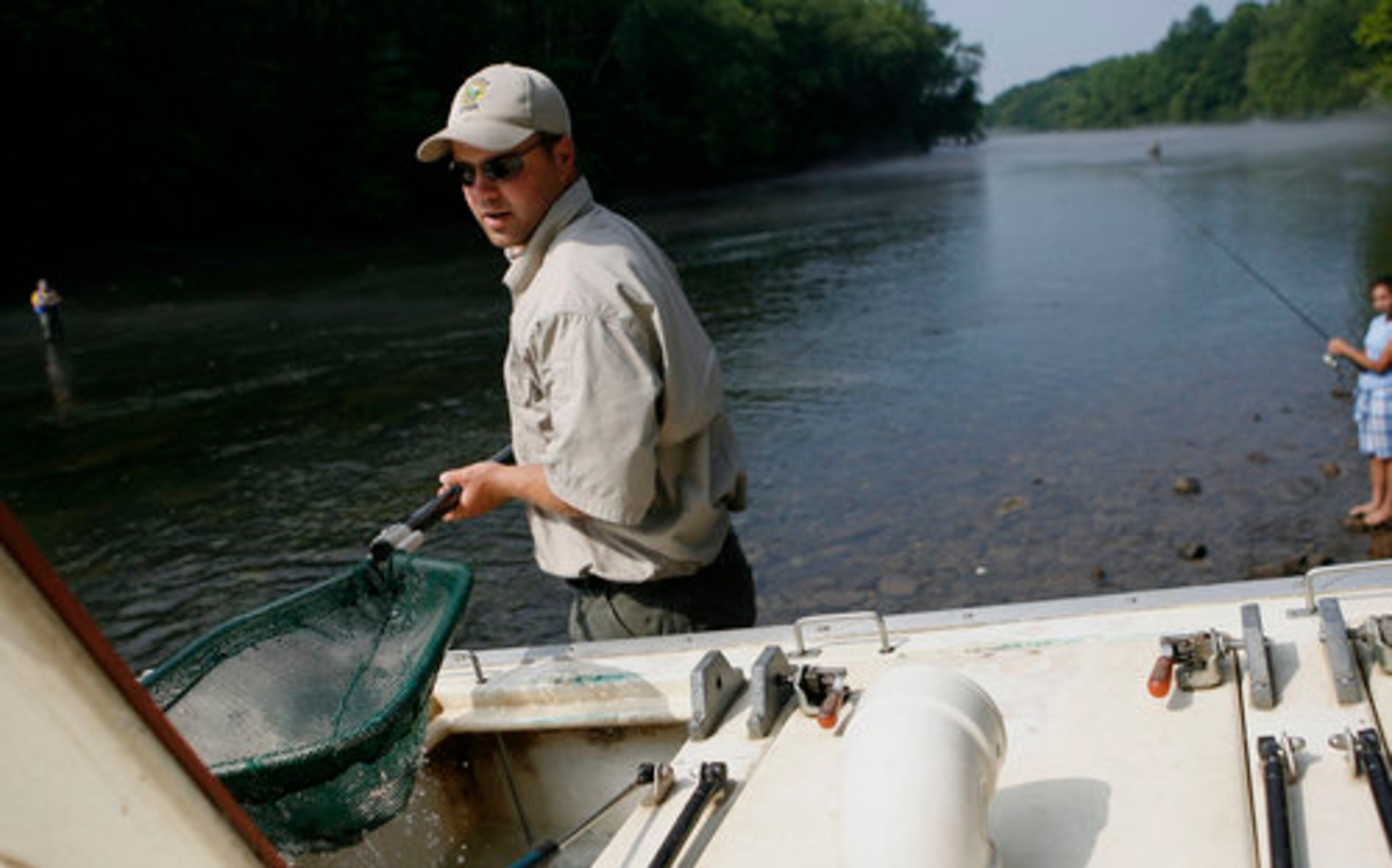 Ryan McIntire on Wednesday releases about 1,000 rainbow trouts by the Lower Pool Park at Buford Dam on the Chattahoochee River. The 10"-14" fish are raised at a nearby hatchery.