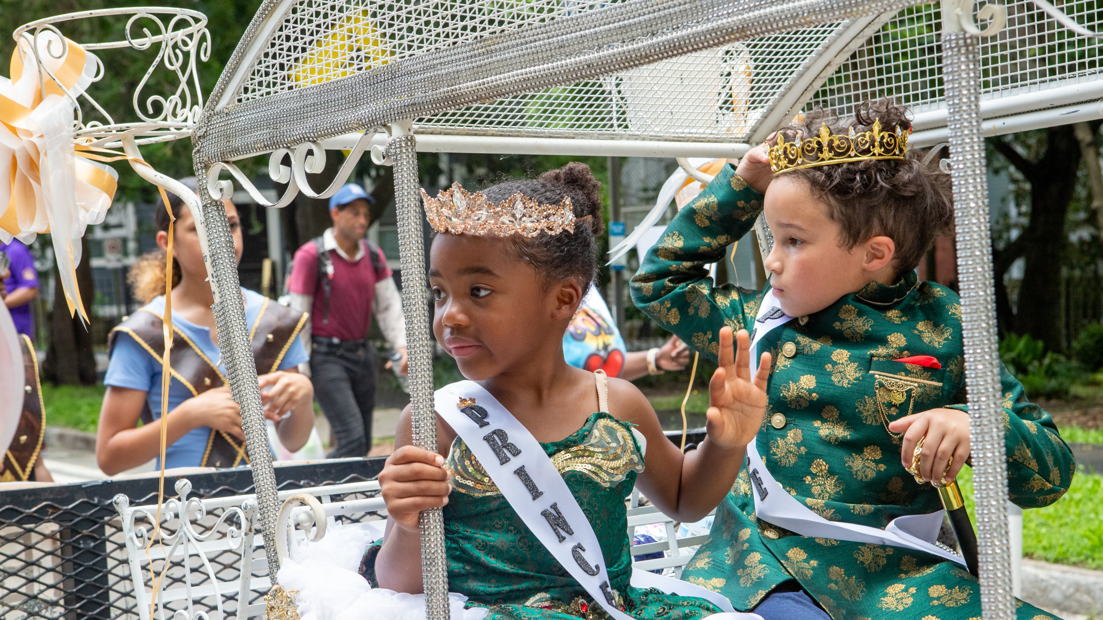 Amelia Hines (left) and London Burden promote a children’s book, “The Adventures of Heirs of Royalty,” during the Juneteenth Atlanta parade on Saturday. (Jenni Girtman for the AJC)