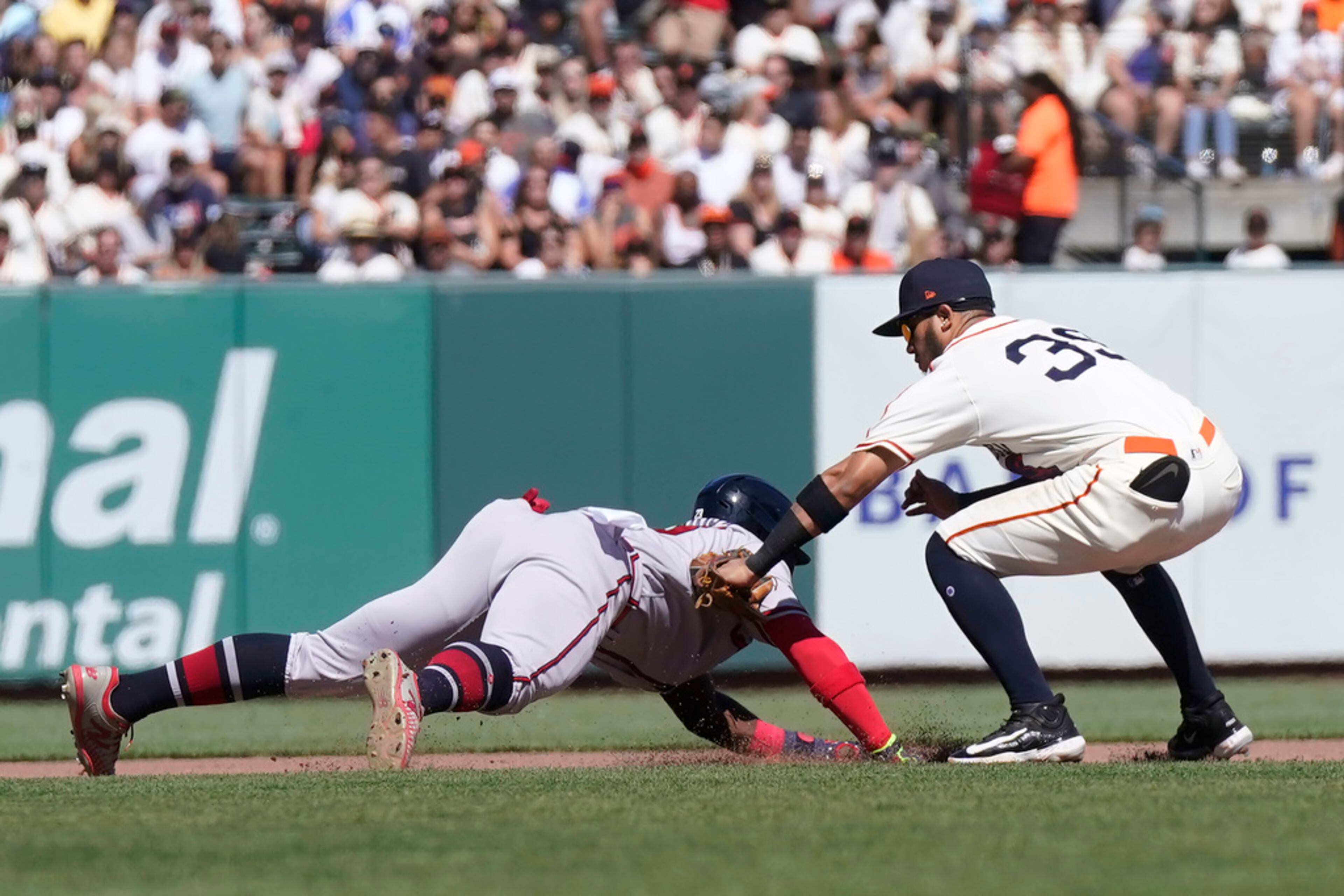 San Francisco Giants second baseman Thairo Estrada, right, tags out Atlanta Braves' Michael Harris II, left, during the seventh inning of a baseball game in San Francisco, Saturday, Aug. 26, 2023. (AP Photo/Jeff Chiu)
