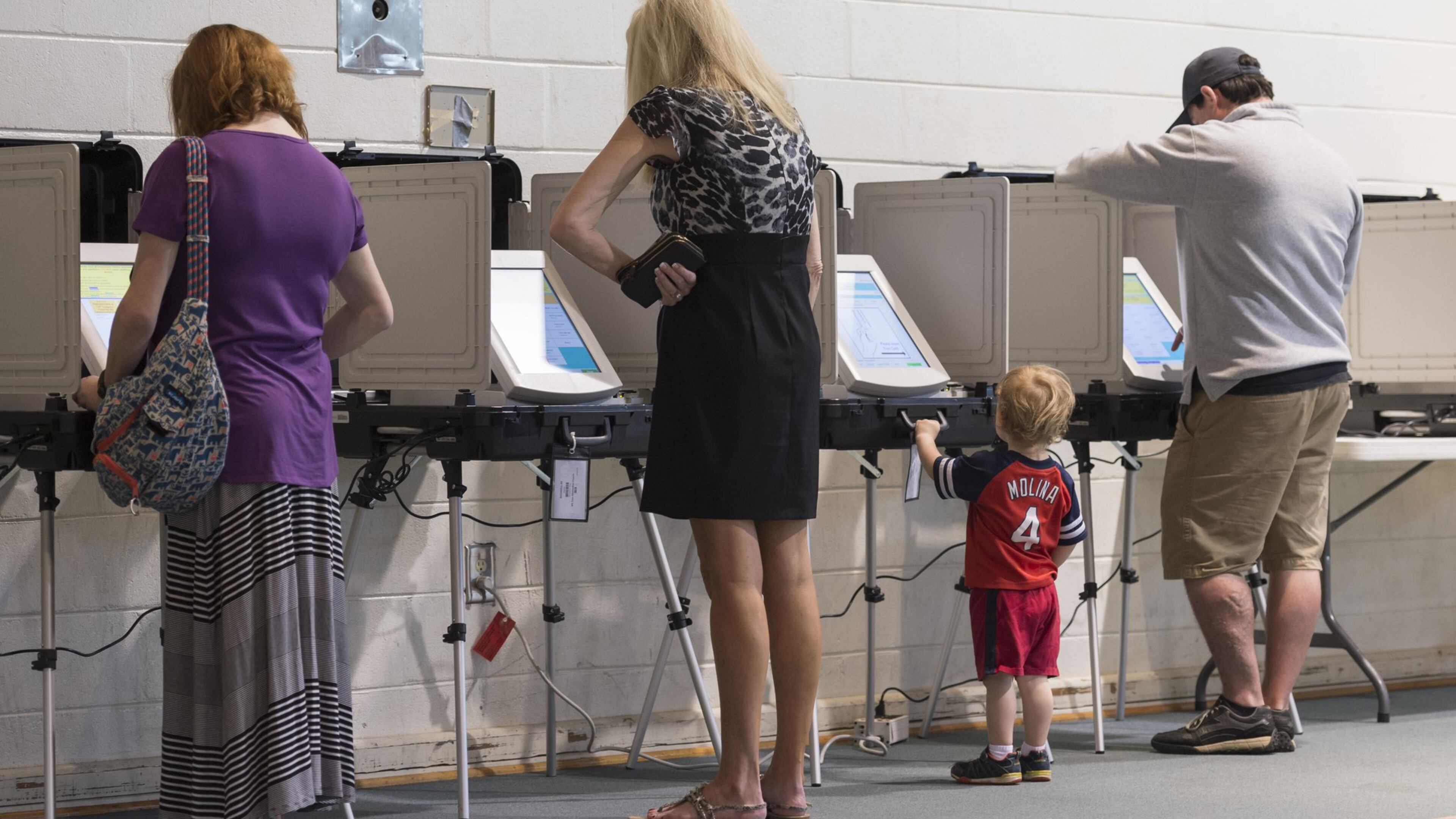 AJ Seger, center right, 2, stands at a voting machine while his mother Mindy Seger, far left, 38, casts her ballot at Mt. Zion United Methodist Church in Marietta, Georgia, on Tuesday, April 18, 2017. Cobb, Fulton and North DeKalb residents cast ballots today for the highly contested 6th Congressional District race. (DAVID BARNES / DAVID.BARNES@AJC.COM)