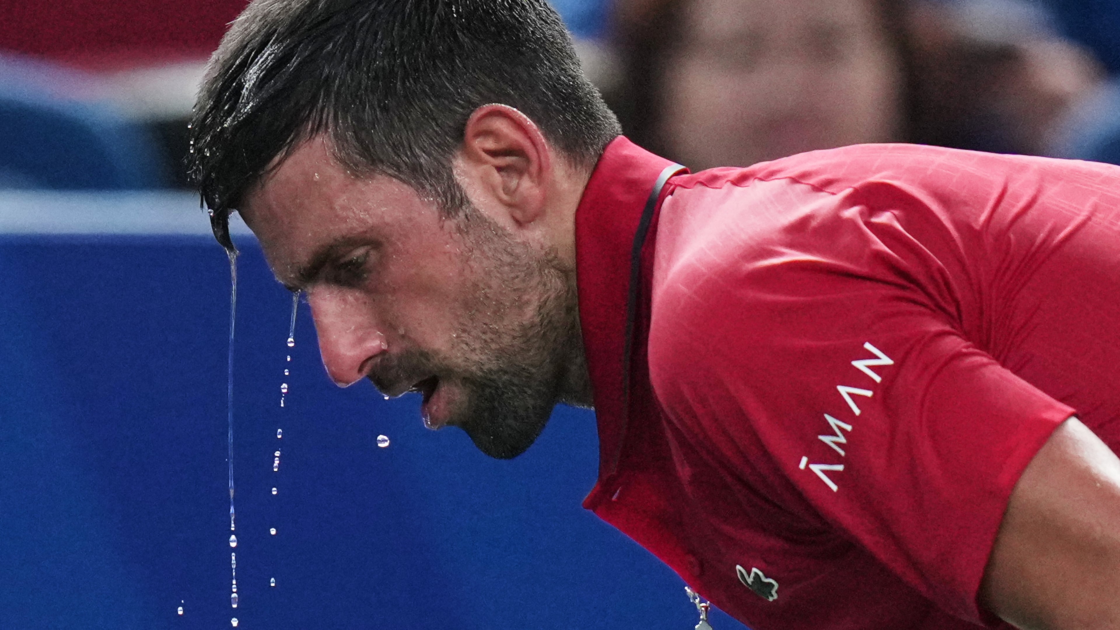 FILE - Novak Djokovic of Serbia cools himself with water during the men's singles semifinal match with Valentin Vacherot of Monaco, at the Shanghai Masters tennis tournament at Qizhong Forest Sports City Tennis Center, in Shanghai, China, Saturday, Oct. 11, 2025. (AP Photo/Andy Wong,File)