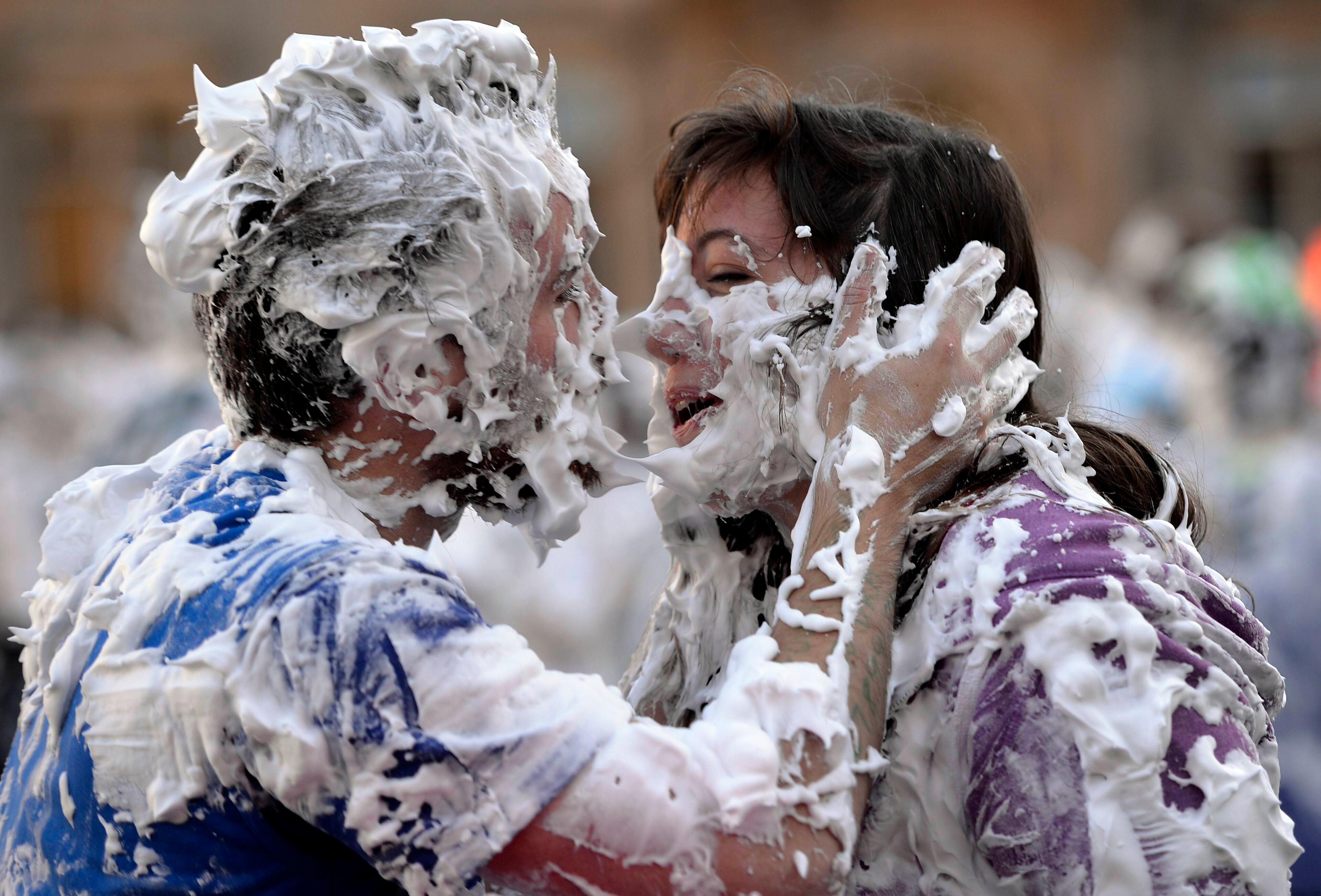Students from St Andrews University are covered in foam as they take part in the traditional 'Raisin Weekend' in the historic St Salvator's Quad, in St Andrews, Scotland November 4, 2013. The weekend, which begins on Sunday, involves rituals for new students, culminating in a foam fight on Monday morning. REUTERS/Russell Cheyne