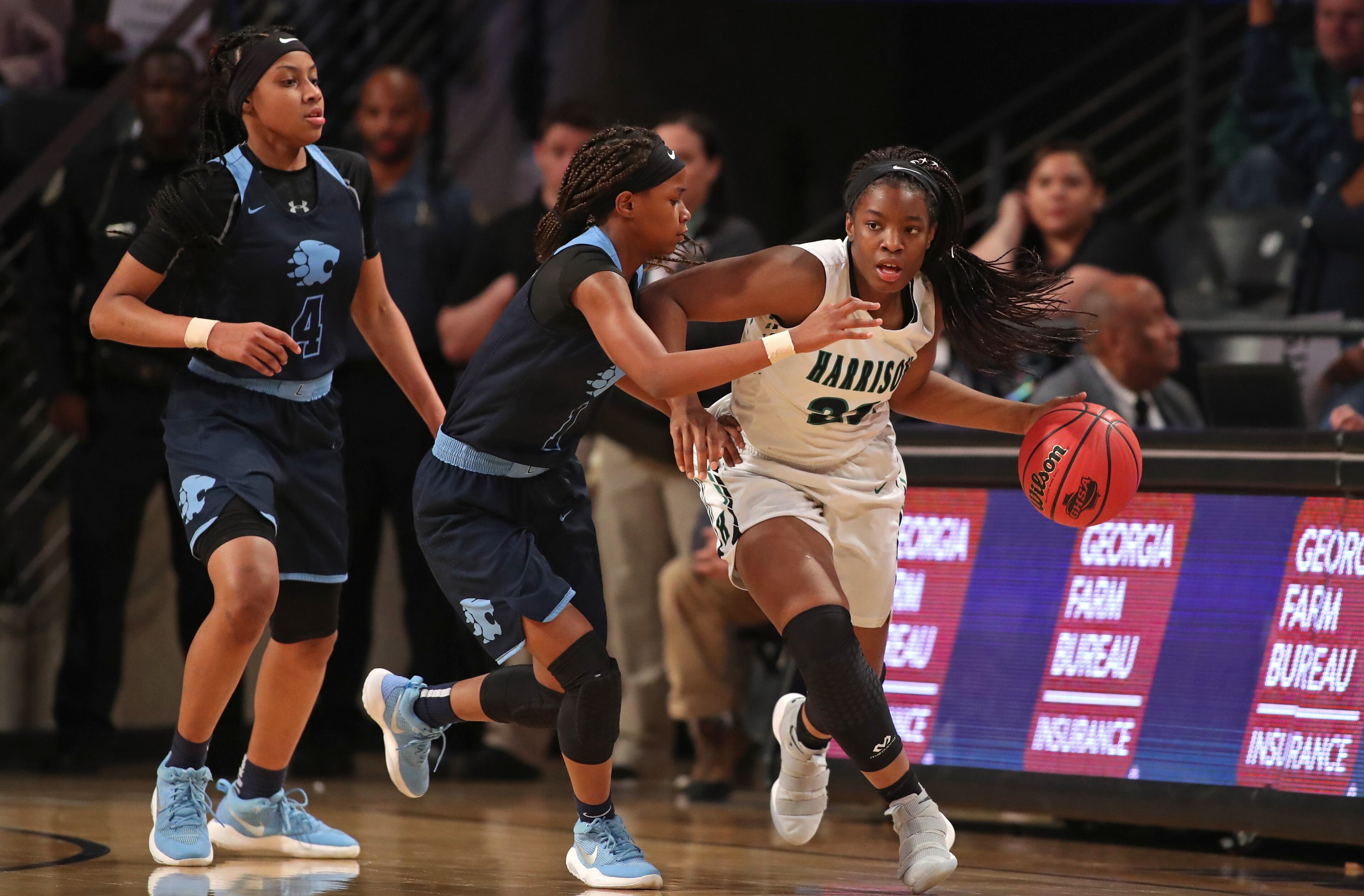 March 9, 2018 - Atlanta, Ga: Harrison guard Sarah Woghiren (22) pushes the ball up the court against Lovejoy guard Genesis Bryant (1) during the first half of the GHSA Class AAAAAA Girls State Championship at McCamish Pavilion Friday, March 9, 2018, in Atlanta. PHOTO / JASON GETZ