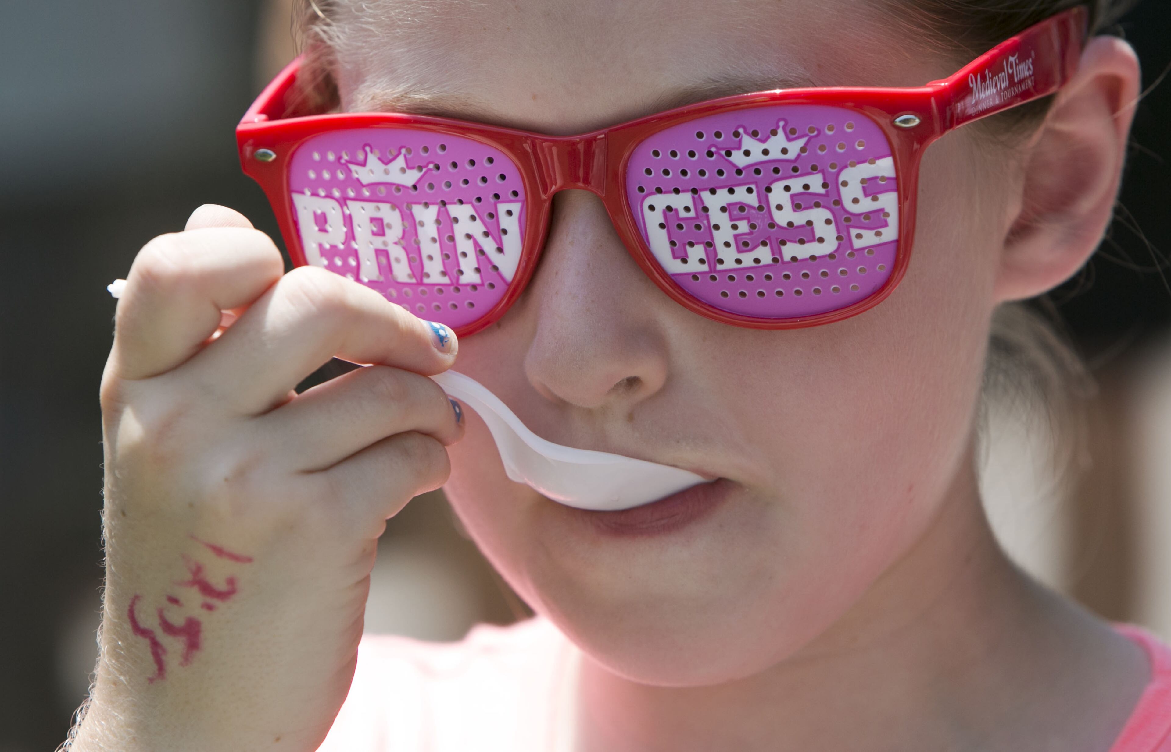Nine-year-old Regan Ernst ate while wearing her "Princess" glasses as local artisans and national classics presented their best products at the 4th Annual Atlanta Ice Cream Festival at Piedmont Park in Atlanta on Saturday, July 26, 2014. There was a variety of health /wellness agencies, fitness routines, vendors, entertainment, bands and fun family activities. (Photo by Phil Skinner)