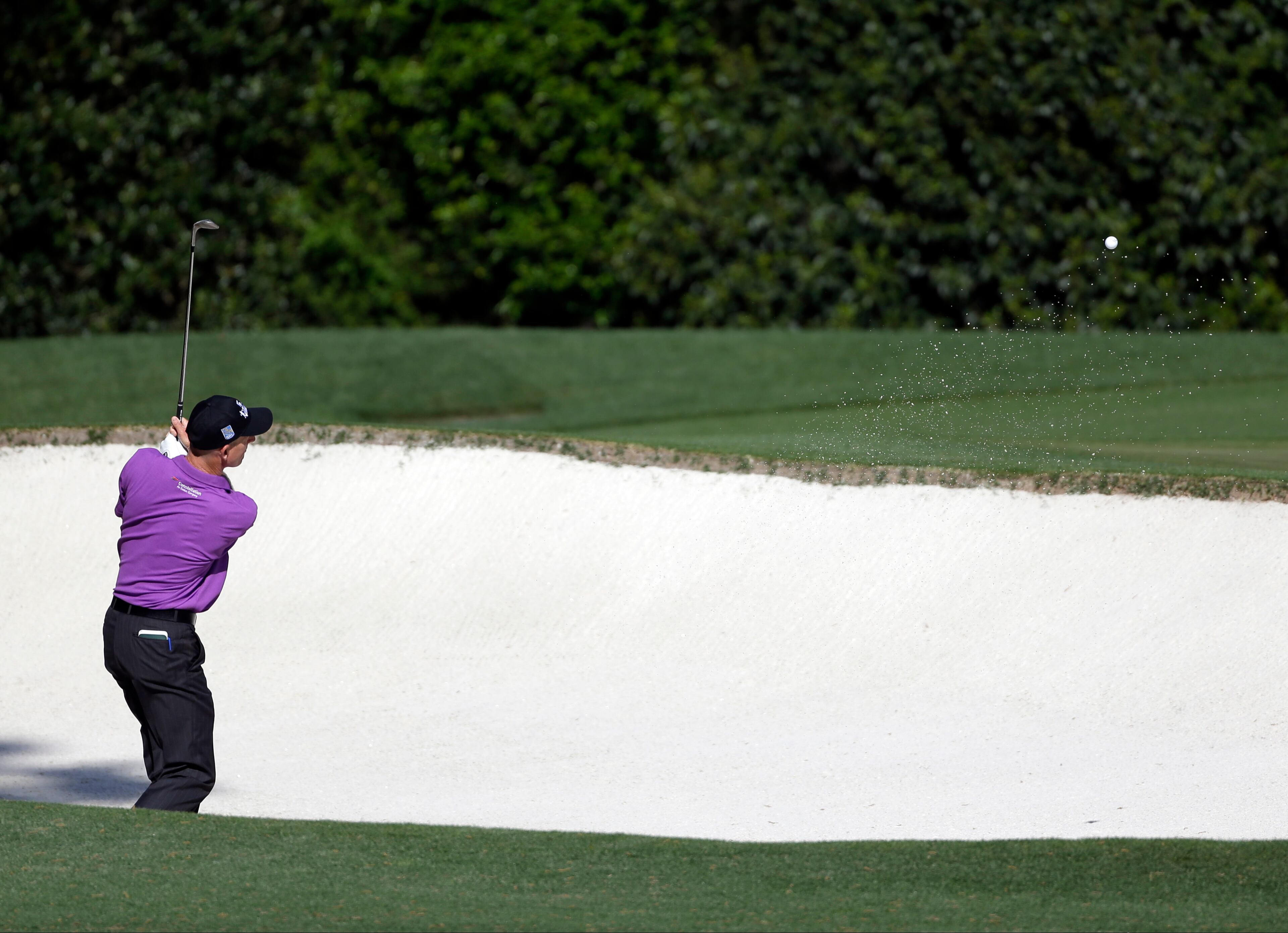 Jim Furyk chips out of a bunker on the fourth hole during a practice round for the Masters golf tournament.