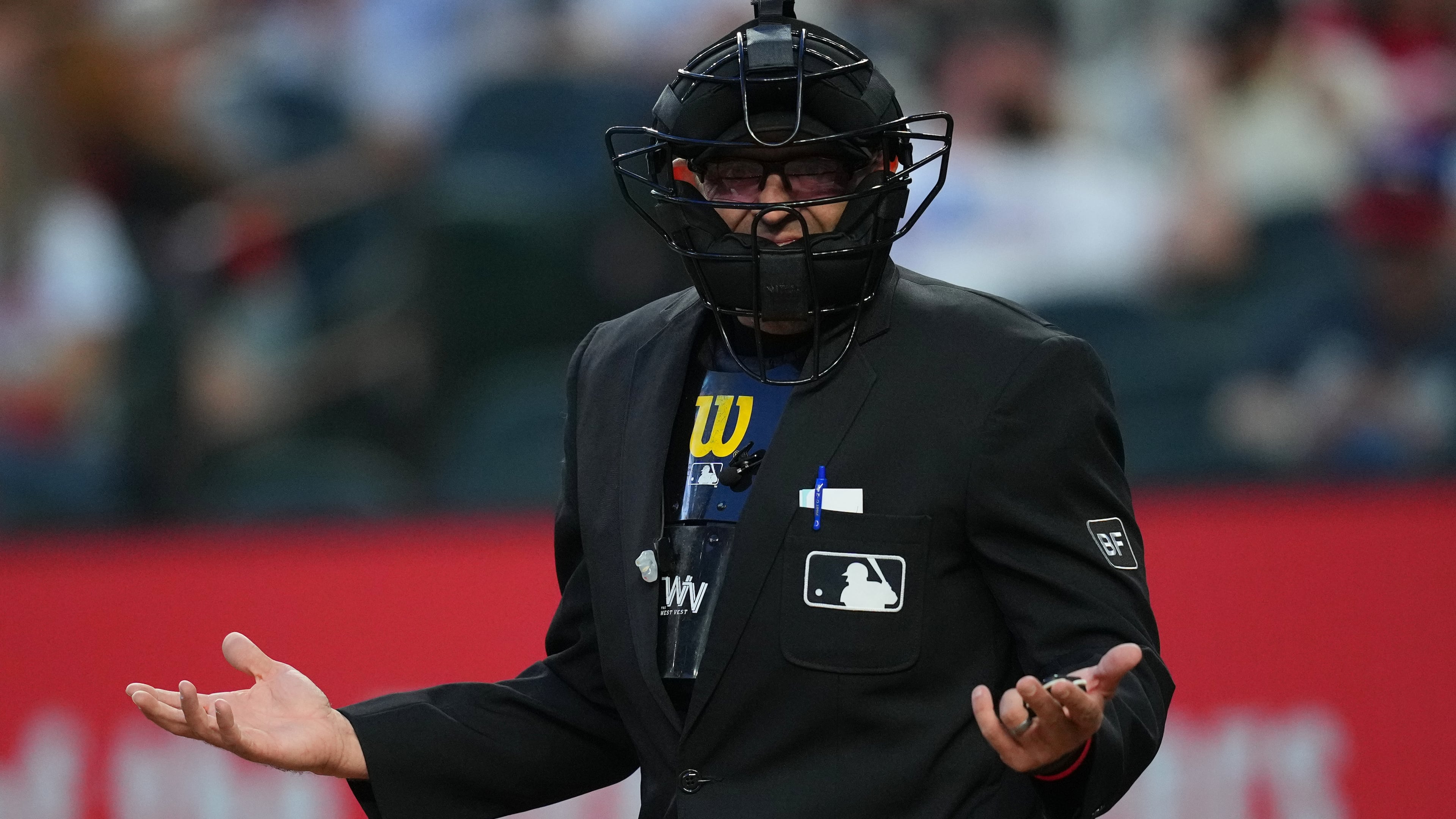 Home plate umpire Alex MacKay reacts toward the Seattle Mariners bench after calling a strike during the third inning of a baseball game against the Texas Rangers, Monday, April 6, 2026, in Arlington, Texas. (AP Photo/Julio Cortez)
