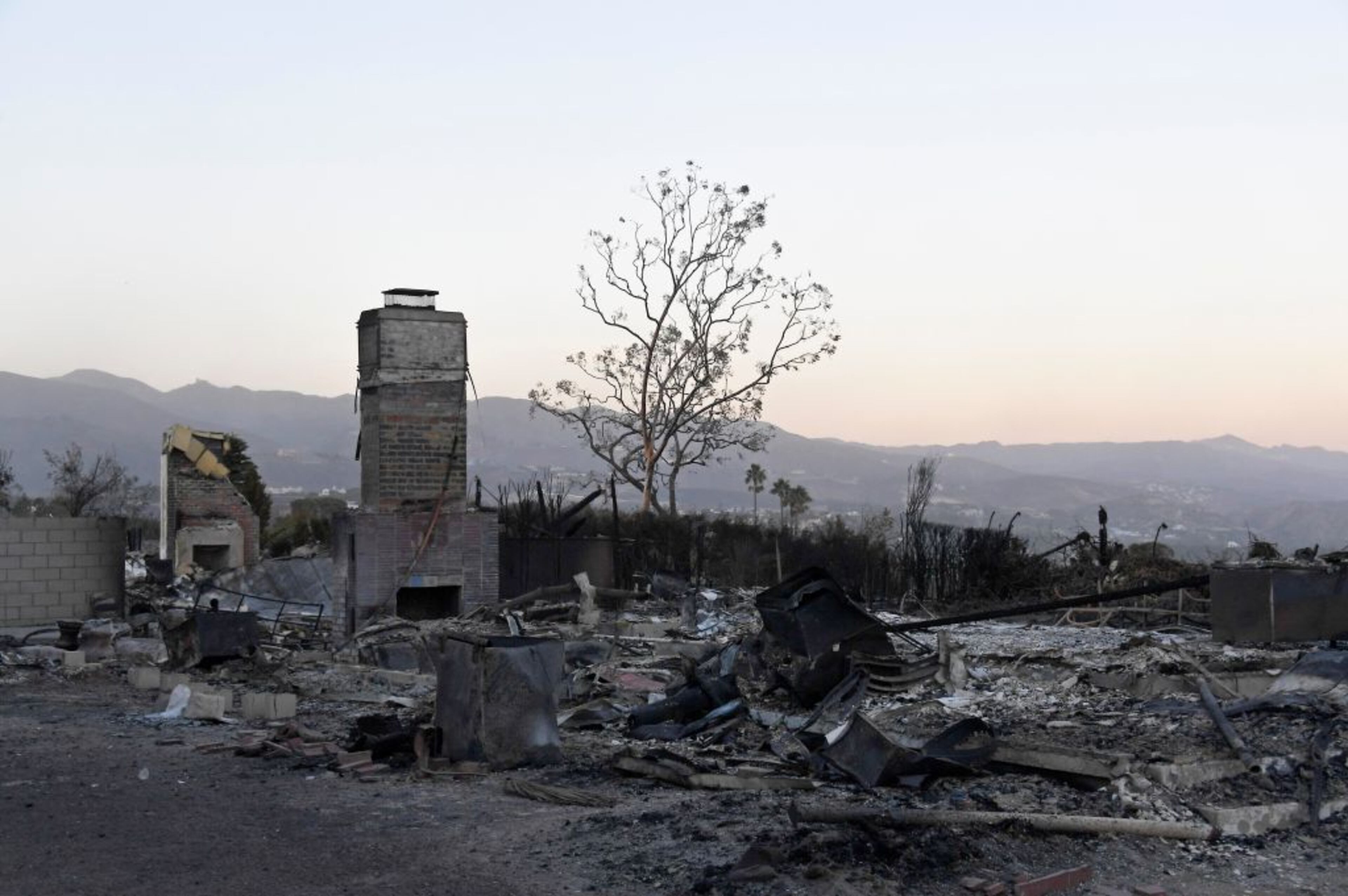 Destroyed houses are seen with the Santa Monica Mountains in the background on November 12, 2018 in Malibu, California, as the Woolsey Fire continues to burn. Multiple fires are burning throughout the state claiming dozens of lives and hundreds of structures.