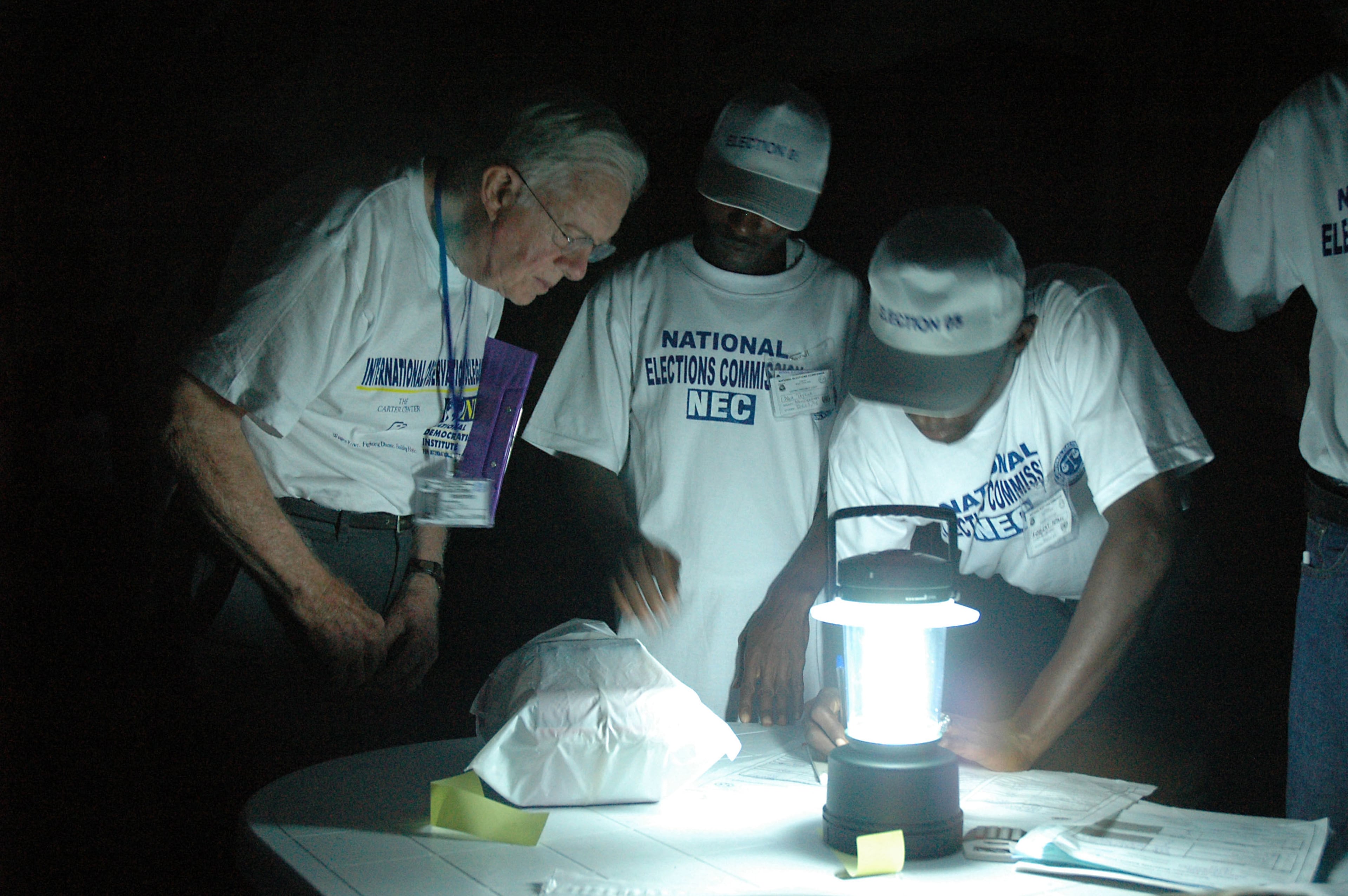 Carter witnesses ballot counting by lamplight at a polling station in Liberia during the Carter Center's observation of presidential elections on Oct. 11, 2005. (The Carter Center)