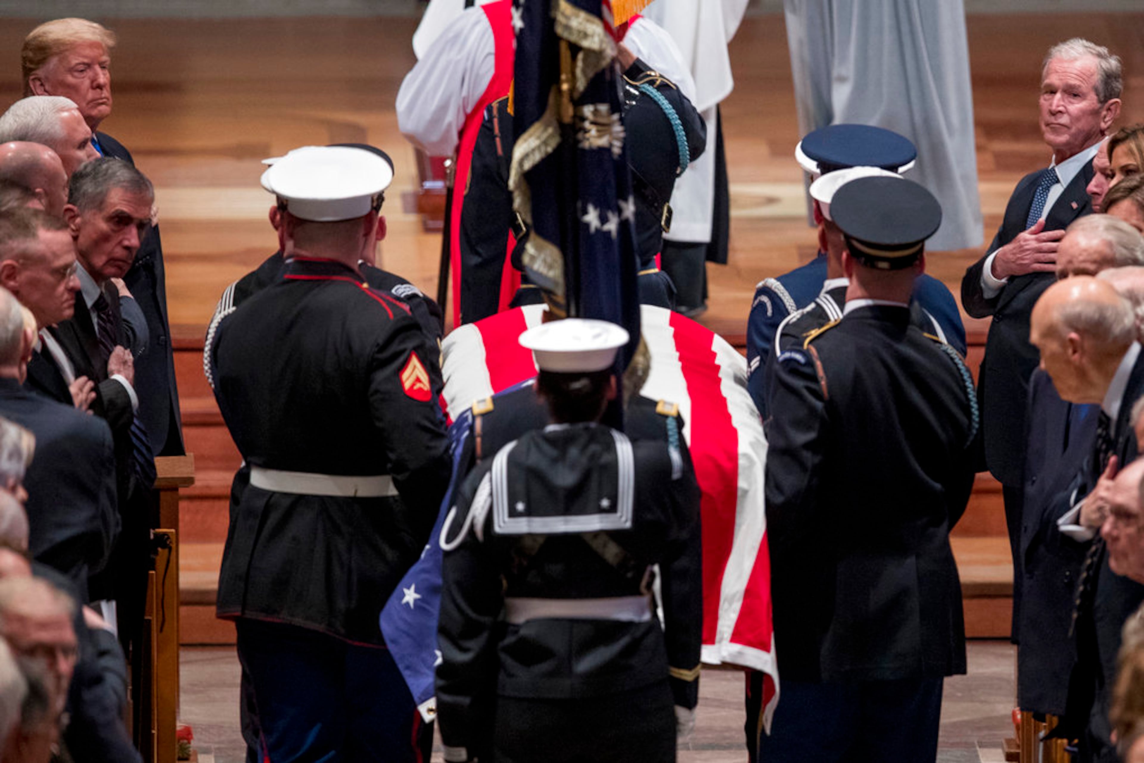 President Donald Trump, top left, and former President George Bush, top right, watch as the flag-draped casket of former President George H.W. Bush is carried by a military honor guard during a State Funeral at the National Cathedral, Wednesday, Dec. 5, 2018, in Washington. (AP Photo/Andrew Harnik, Pool)
