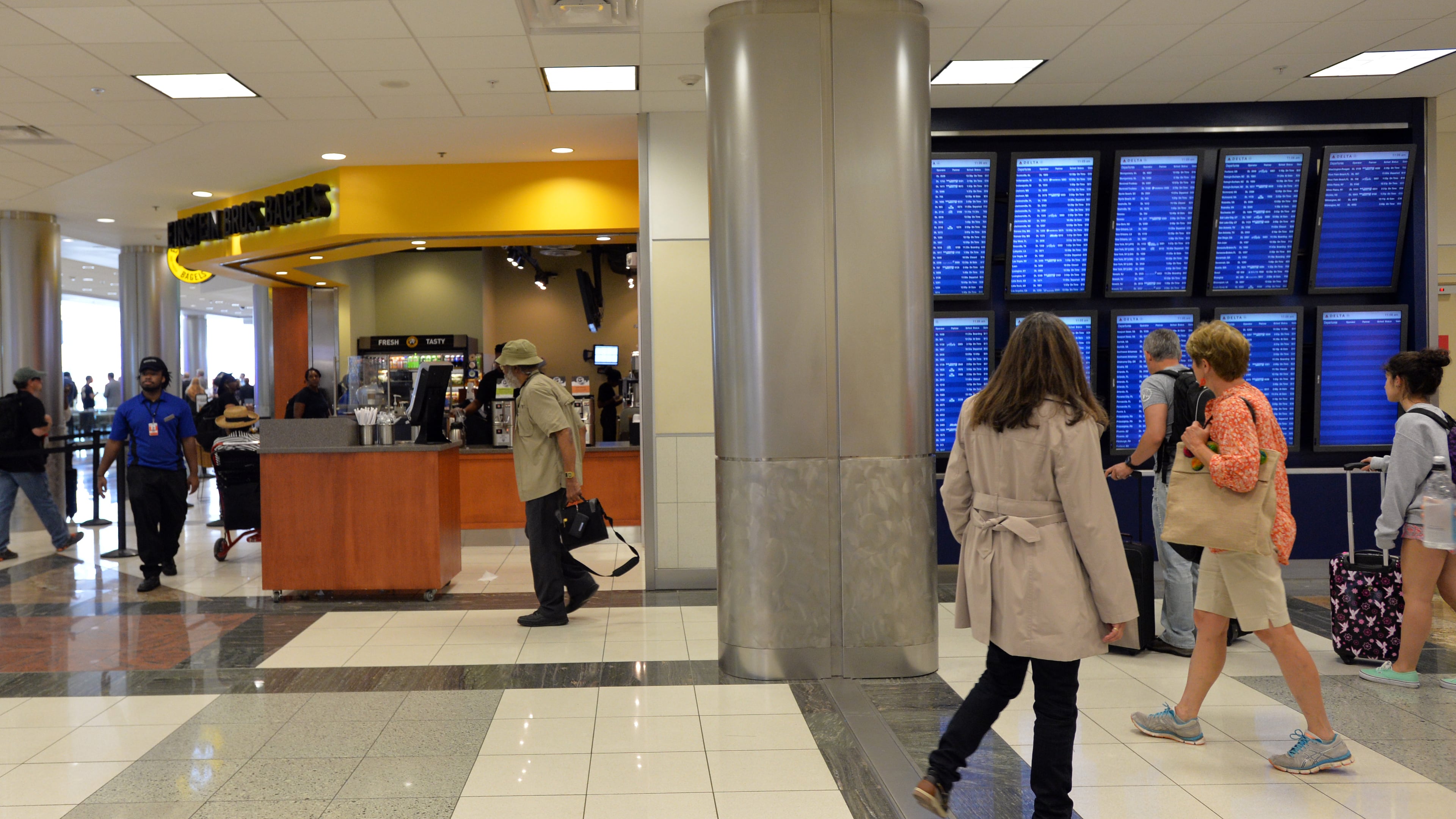 Airport travelers walk past new restaurants including Einstein Bros Bagels in Concourse D. HYOSUB SHIN / HSHIN@AJC.COM