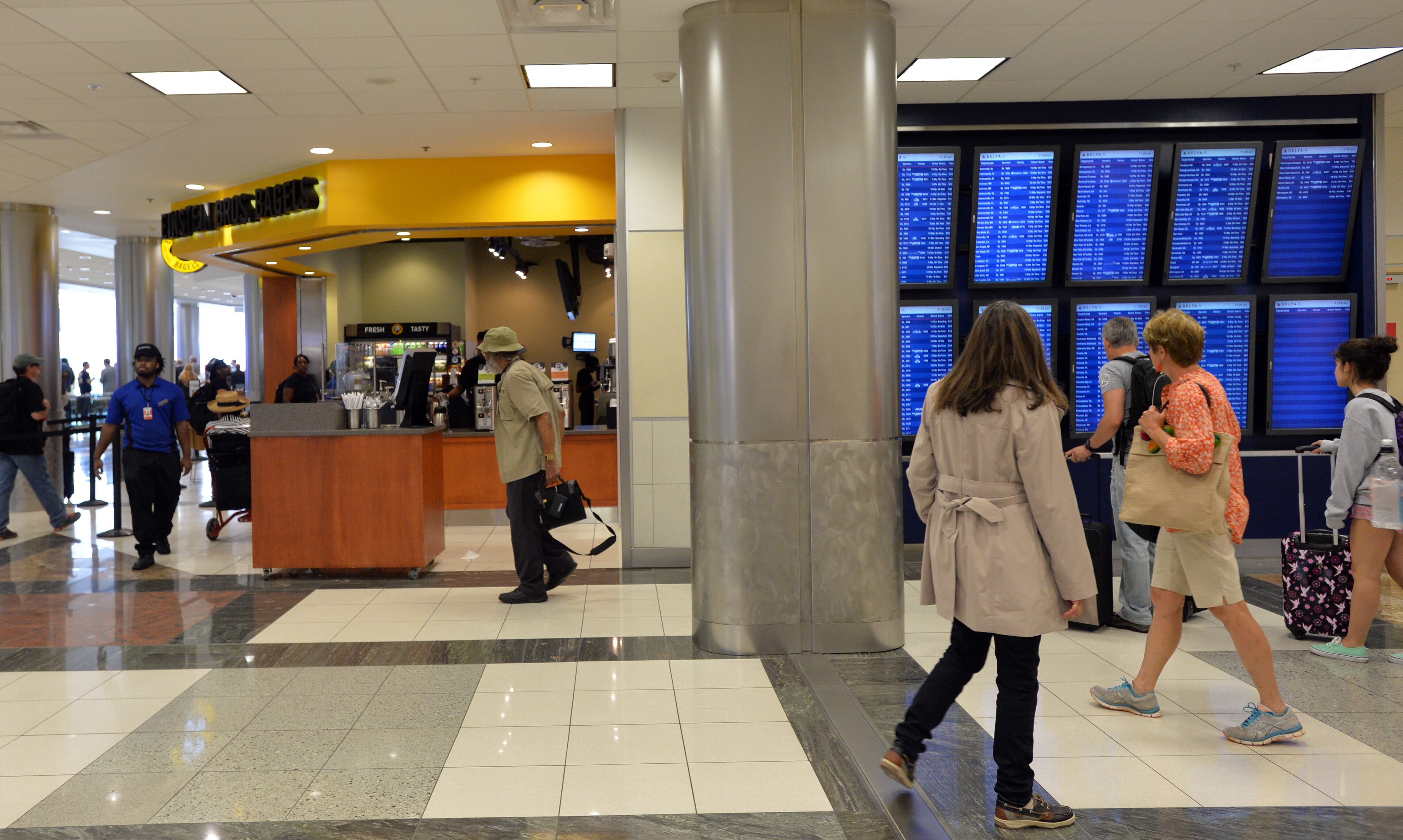 June 24, 2014 Atlanta - Airport travelers walk past new restaurants including Einstein Bros Bagels in Concourse D, Hartsfield-Jackson Atlanta International Airport on Tuesday, June 24, 2014. Hartsfield-Jackson and Delaware North celebrate the newest additions to Concourse D, including local favorites GrindHouse Killer Burgers and Yoforia, and national brands 40/40 Club and Food Network Kitchen. HYOSUB SHIN / HSHIN@AJC.COM