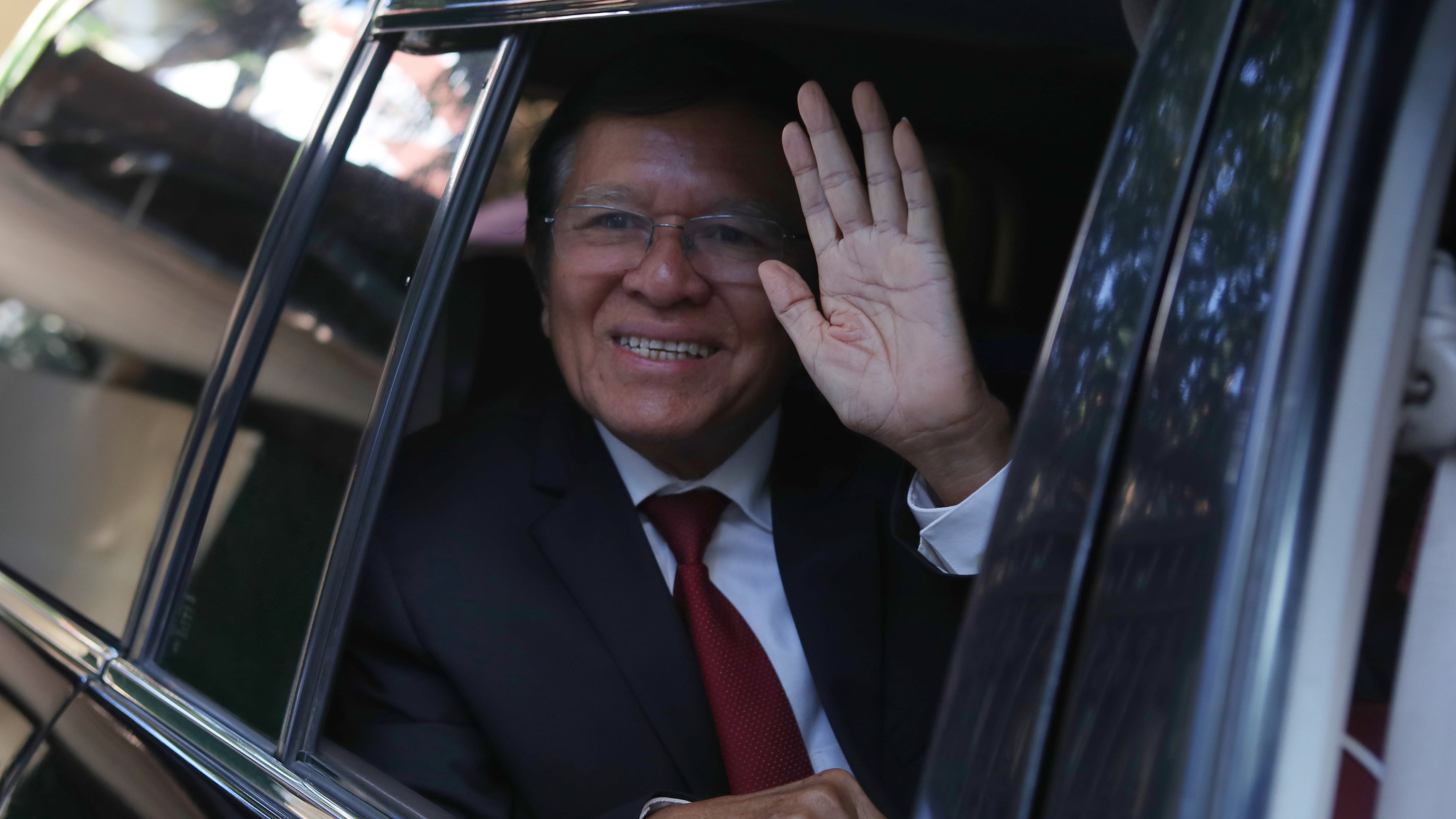 FILE -Former President of Cambodia National Rescue Party, Kem Sokha, greets from his car in front of his house in Phnom Penh, Cambodia, Friday, March 3, 2023. (AP Photo/Heng Sinith, File)