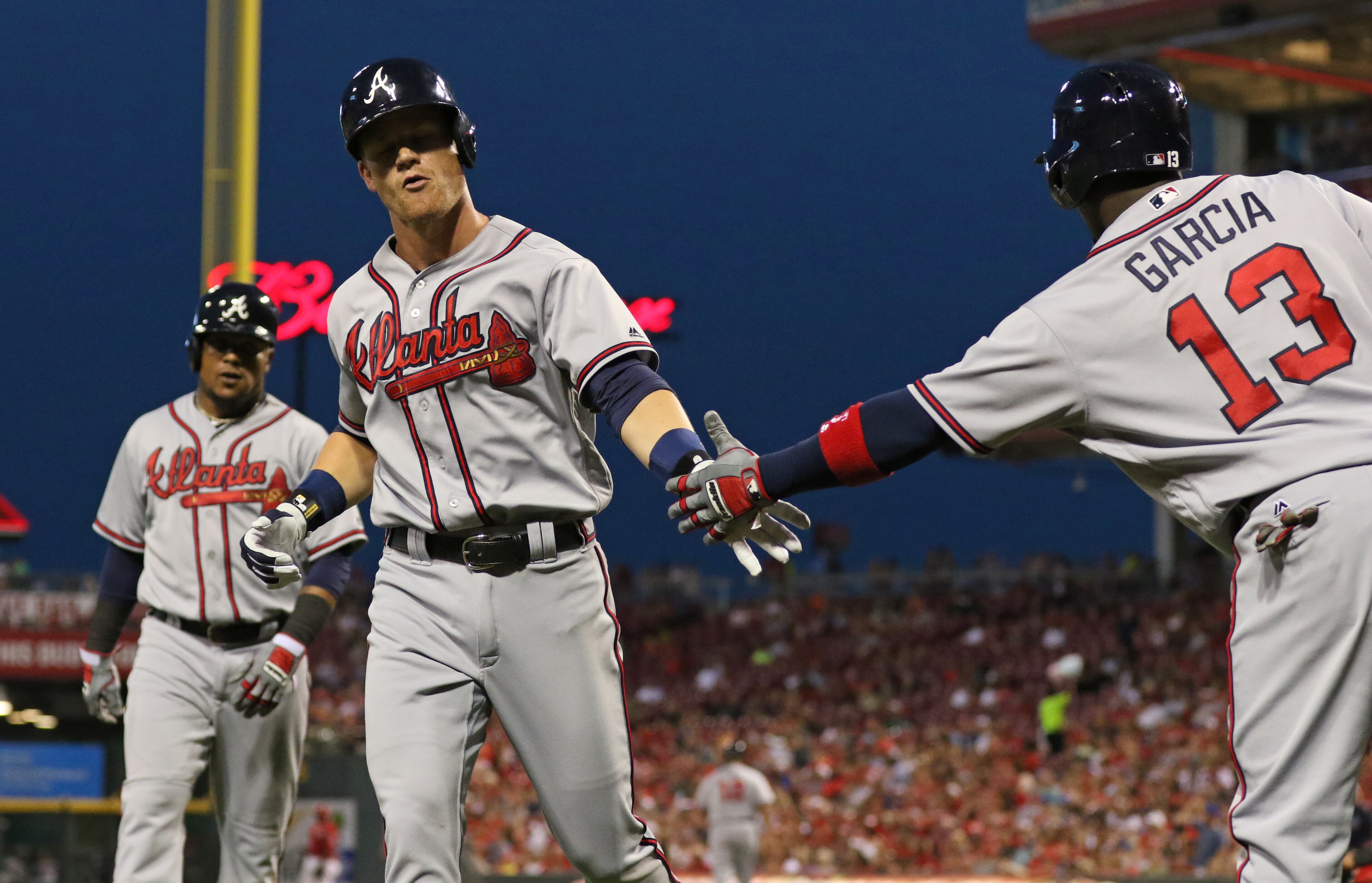 Atlanta Braves' Gordon Beckham, center is congratulated by Adonis Garcia (13) on a two-run homer, scoring Erick Aybar, left, off the Cincinnati Reds relief pitcher Michael Lorenzen (21) during the seventh inning of a baseball game, Tuesday, July 19, 2016, in Cincinnati. (AP Photo/Gary Landers)