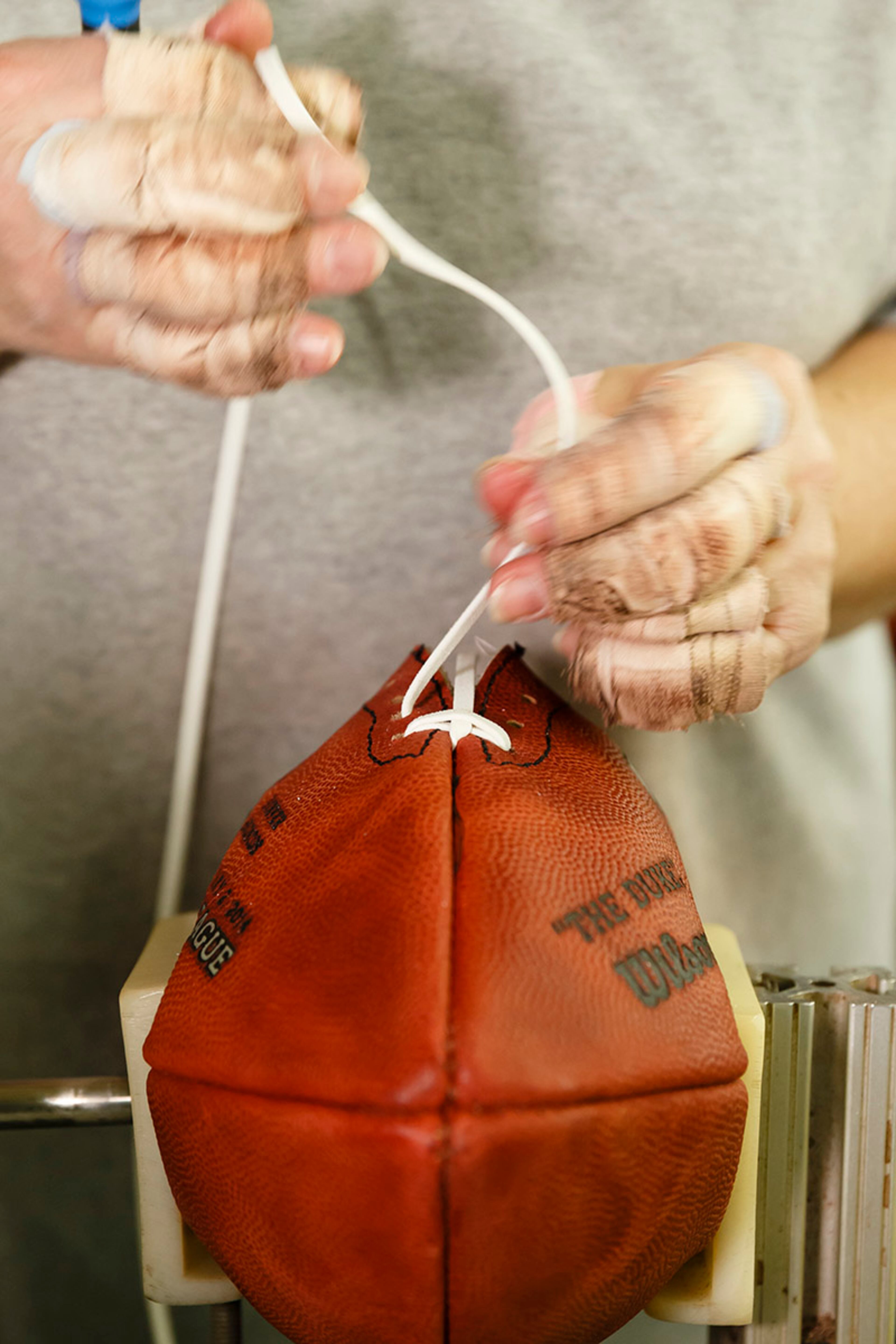 Donna Connelly threads the laces of an official game ball for the NFL football Super Bowl XLVIII at the Wilson Sporting Goods Co. in Ada, Ohio, Monday, Jan. 20, 2014. The Seattle Seahawks will play the Denver Broncos in the Super Bowl on Feb. 2 in New Jersey. (AP Photo/Rick Osentoski)