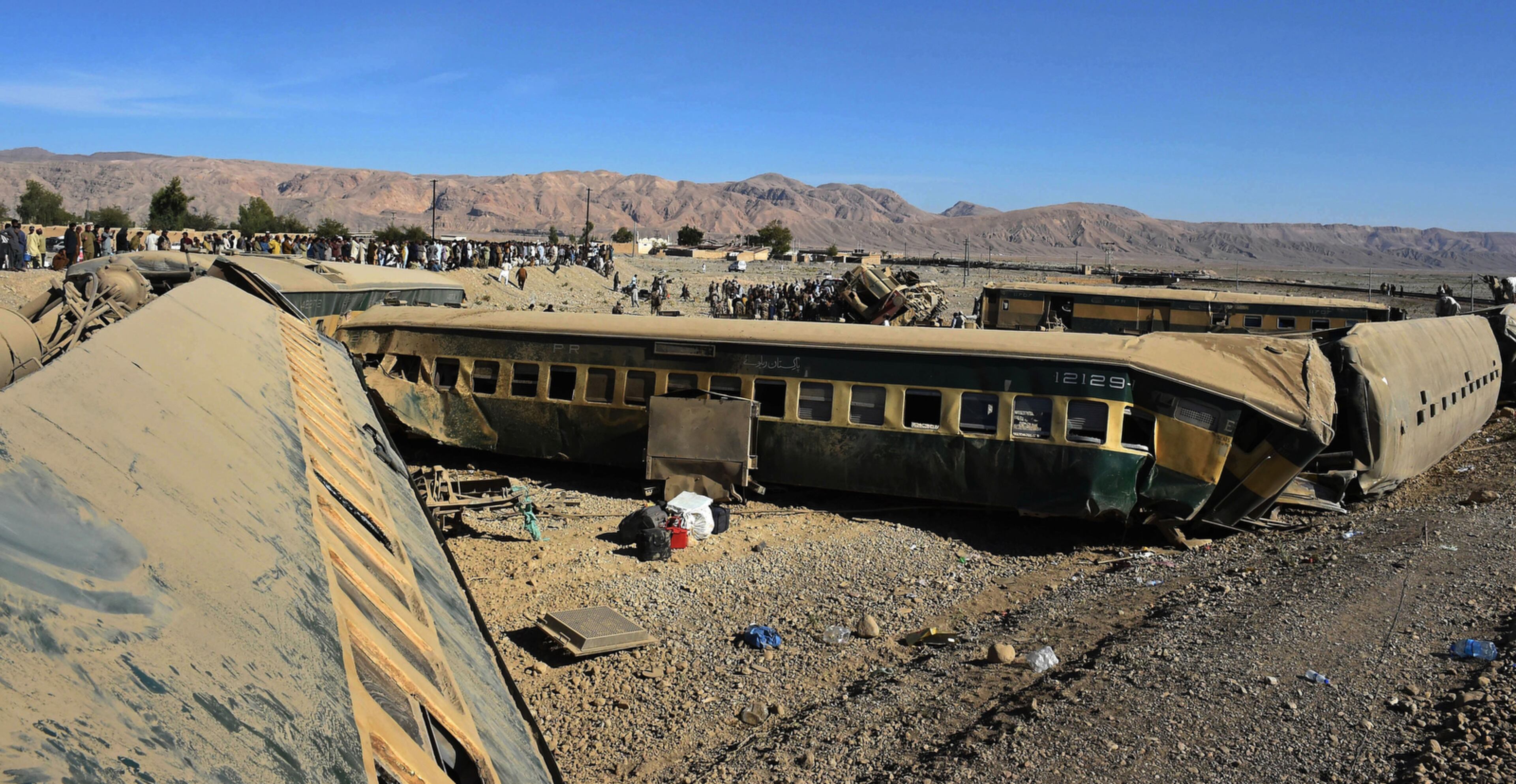 PAKISTAN TRAIN WRECK--People gather at the site of a train accident in Abe Ghum near Quetta, Pakistan, Tuesday, Nov. 17, 2015. A train carrying 280 passengers derailed in a remote area of southwestern Pakistan on Tuesday, killing the train driver and many passengers and injuring at least 57 people, officials said. (AP Photo/Arshad Butt)
