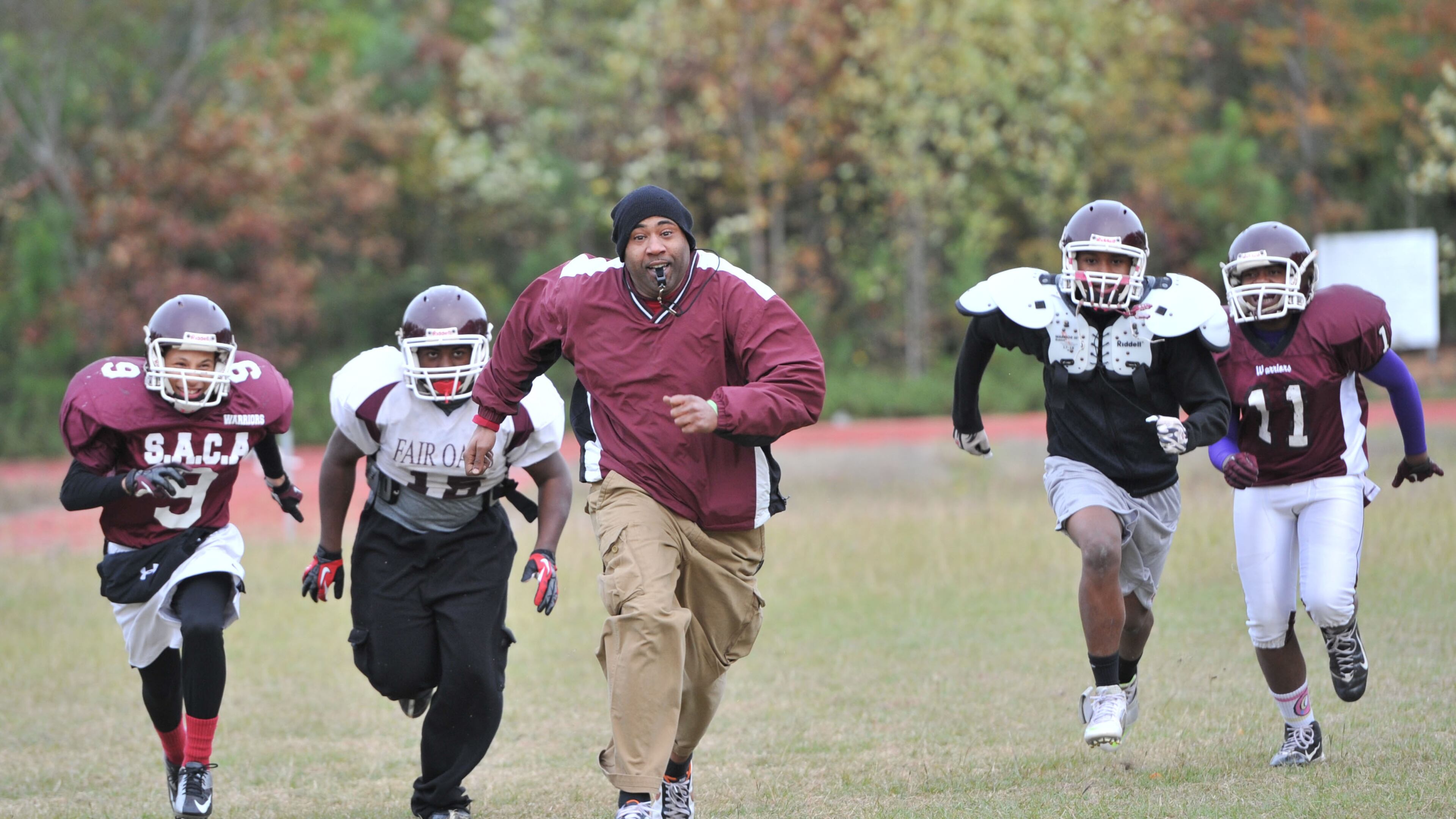 Southwest Atlanta Christian assistant head coach Stan Wallace races with his players at the end of their football practice. HYOSUB SHIN / HSHIN@AJC.COM