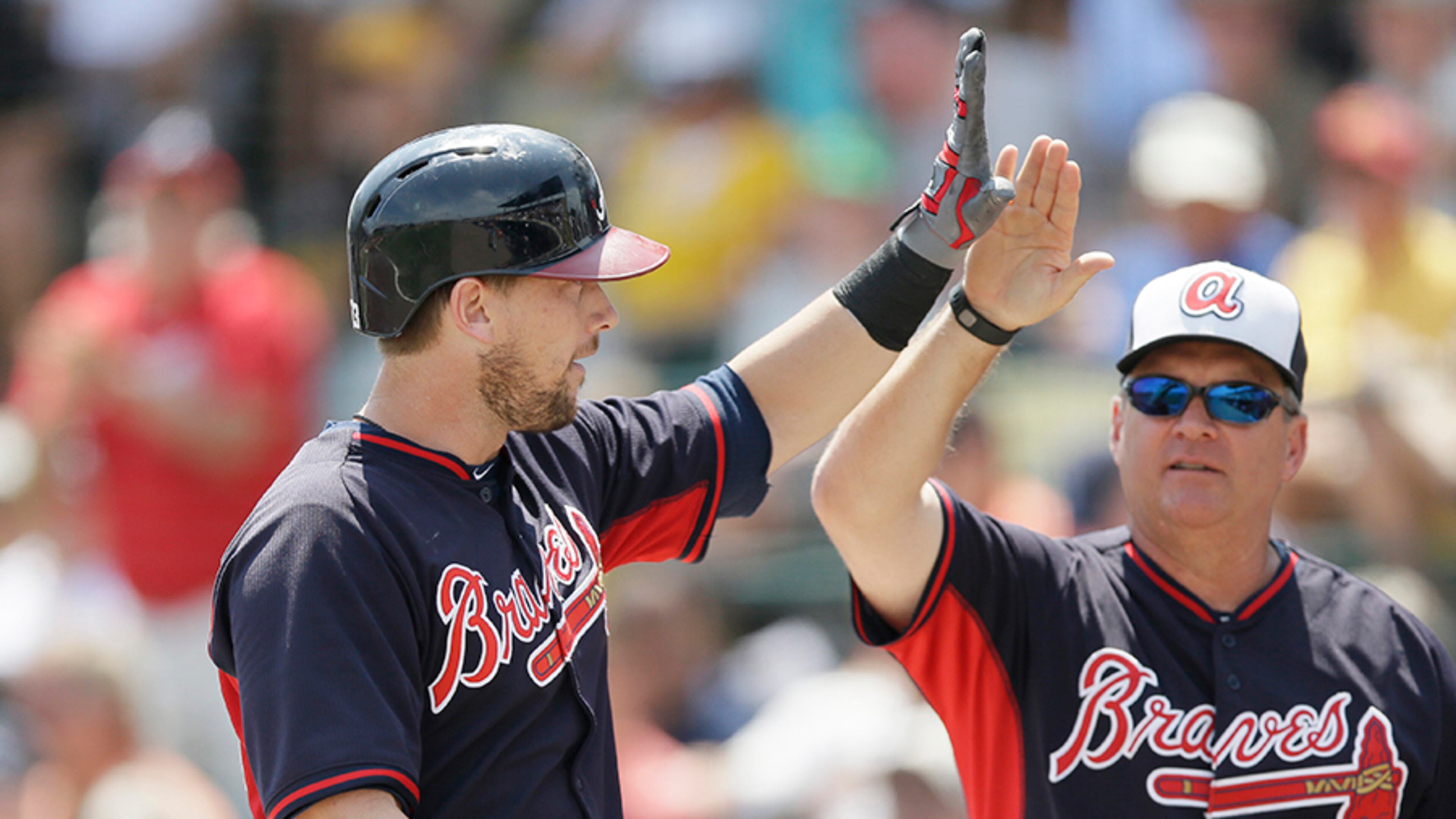 Braves infielder Chris Johnson (left) is congratulated by hitting coach Kevin Seitzer after hitting a two-run home run in a spring training game.