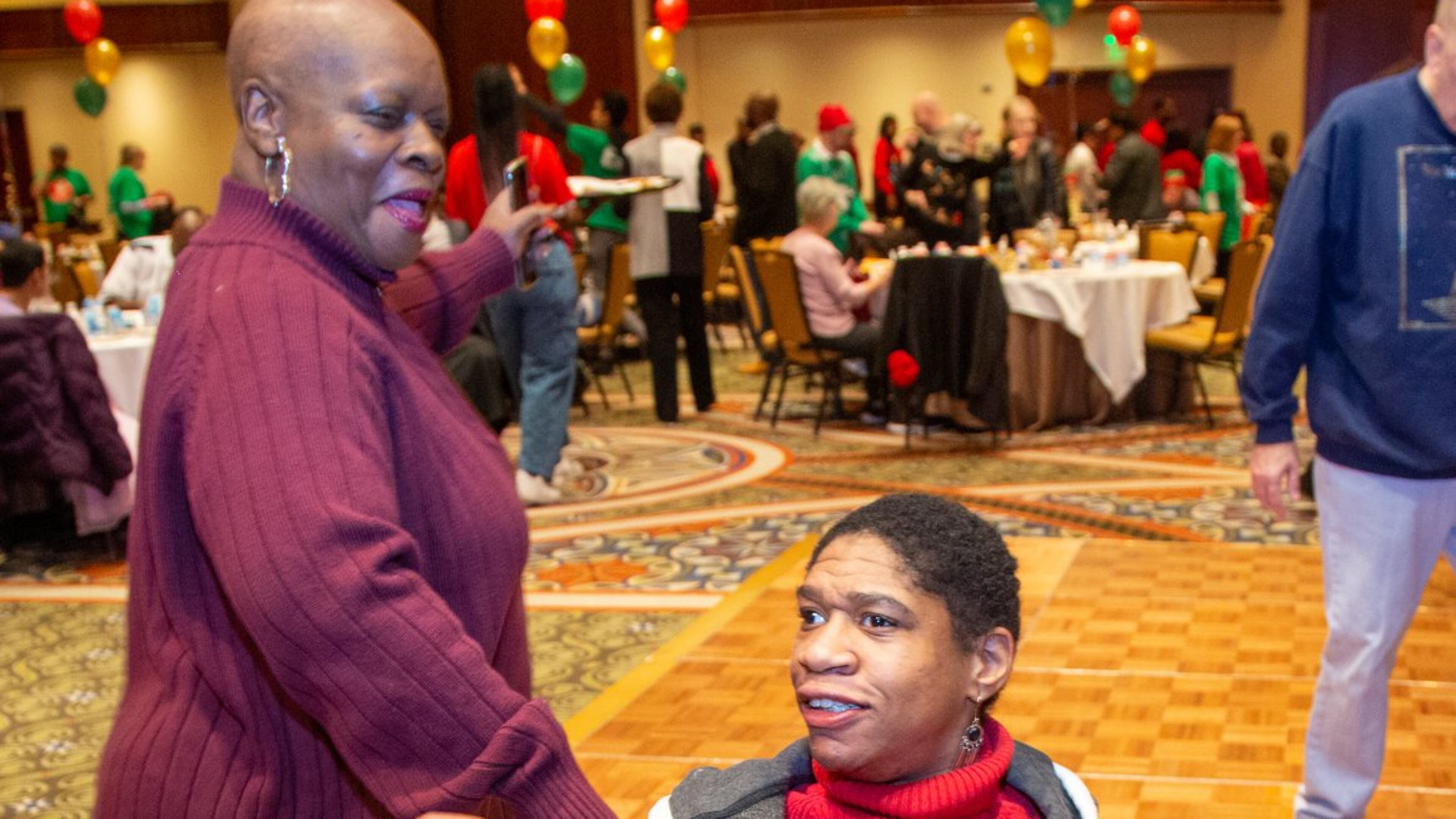 Sharon Gary-Dill (standing) danced with Sierra Stanley as hundreds of special needs Atlantans and their caregivers celebrated together at the Omni Hotel in Atlanta during the Christmas party for Atlanta’s special citizens 50th anniversary. (Photo by Phil Skinner)