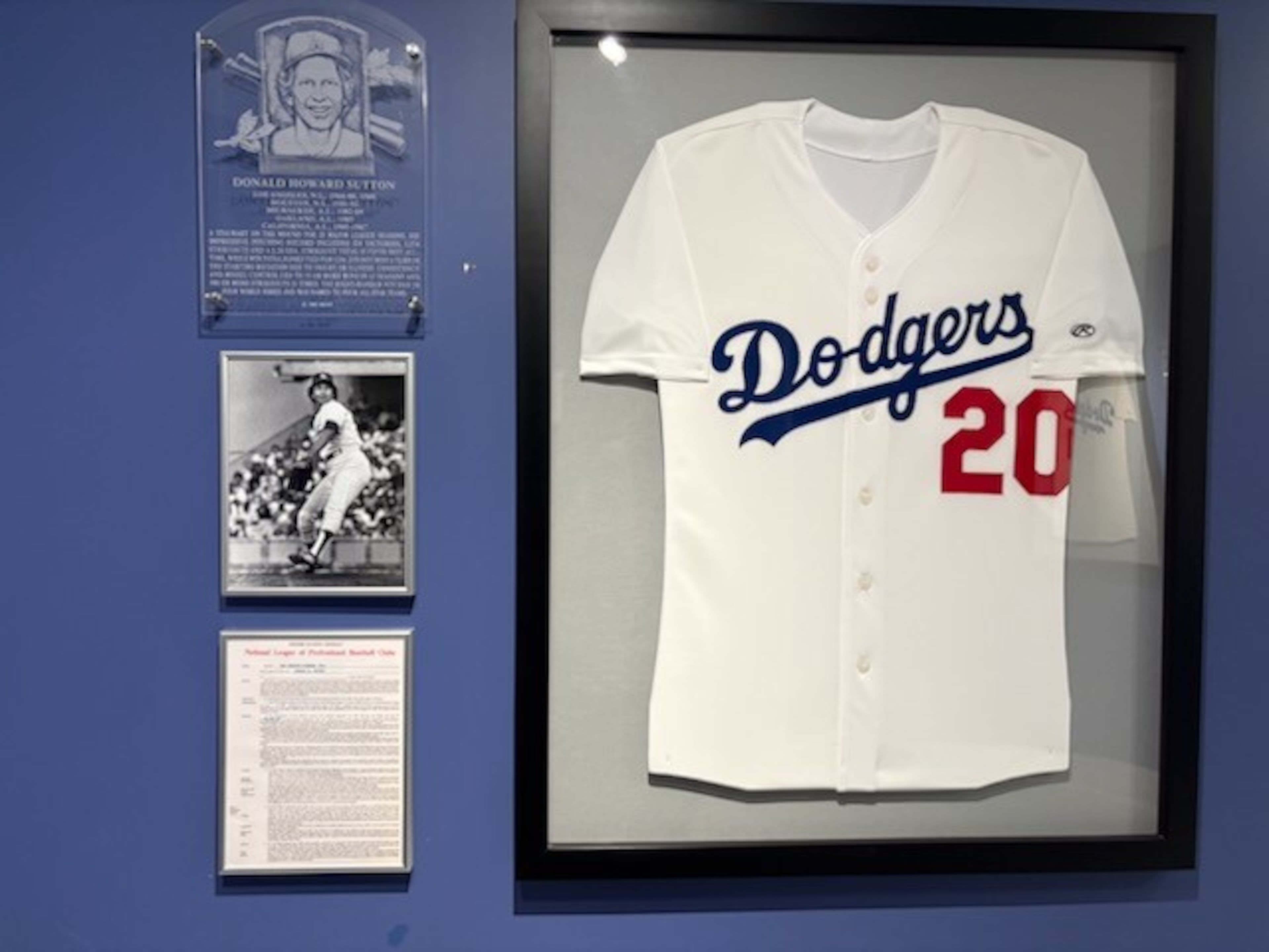 That jersey of the late Don Sutton, beloved Braves broadcaster, hanging in Dodger Stadium in a hallway on the clubhouse level. The framed document on the lower left is his 1969 contract. (Ken Sugiura/AJC)