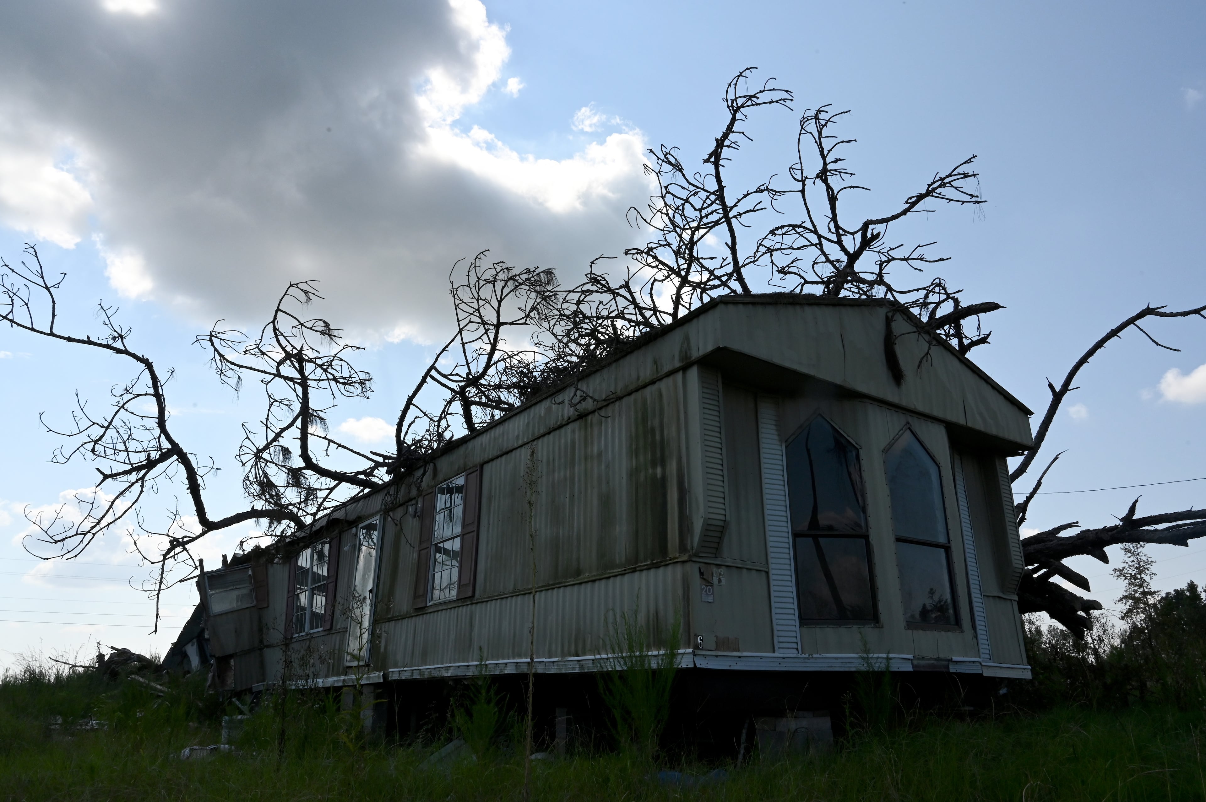 A mobile home on Bell Telephone Road in Hazleton sits vacant nearly a year after a tree fell on a home in the same mobile home community, killing a person inside. (Hyosub Shin/AJC)