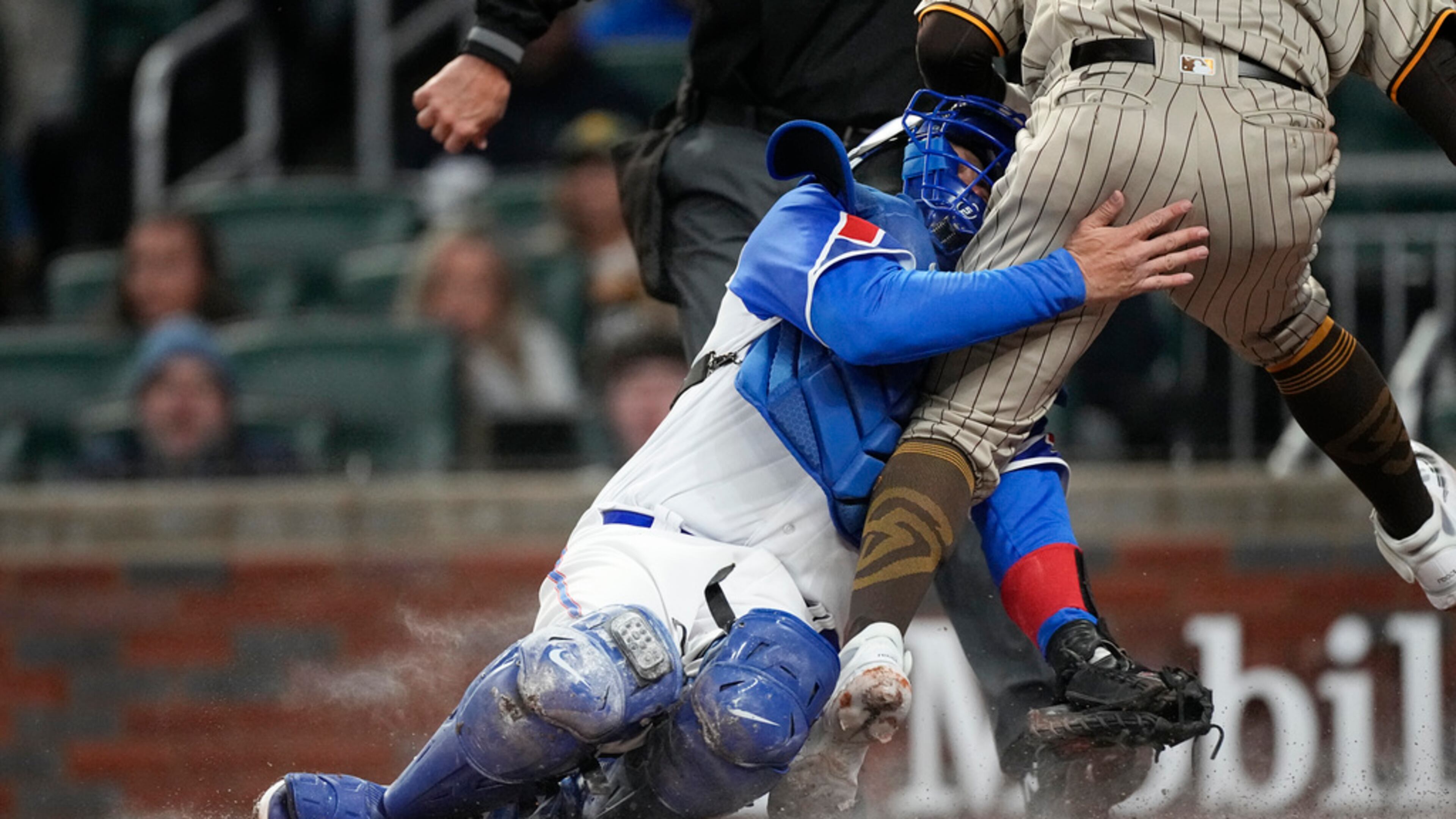 San Diego Padres' Rougned Odor (24) collides with Atlanta Braves catcher Travis d'Arnaud (16) during the fourth inning of a baseball game Saturday, April 8, 2023, in Atlanta. (AP Photo/John Bazemore)
