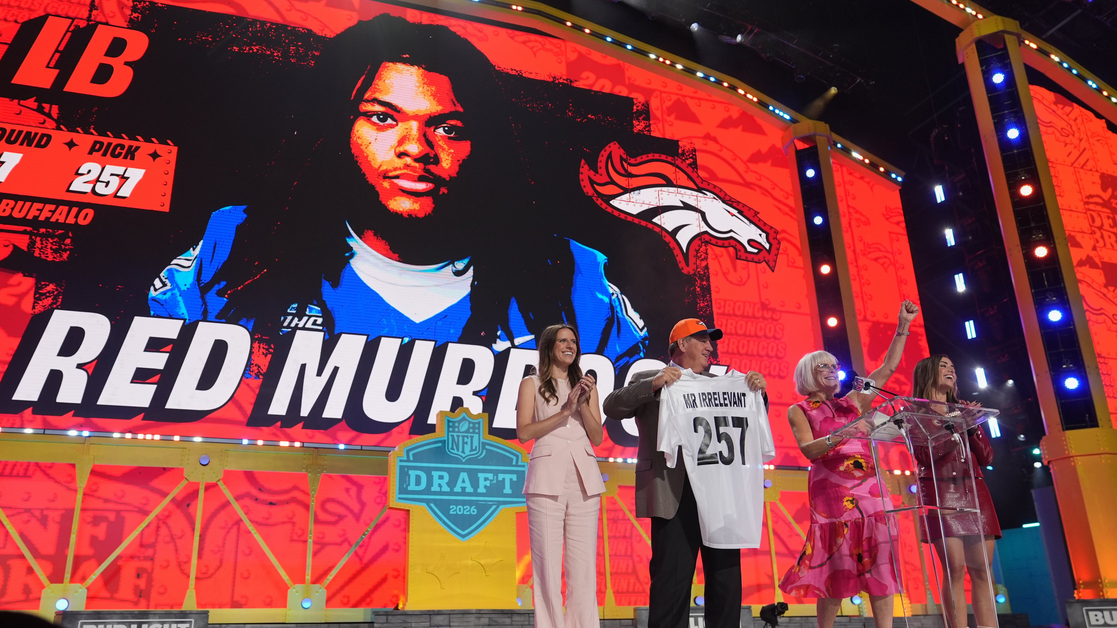 Melanie Salata Fitch, second from right announces Red Murdock as the final pick, referred to as Mr. Irrelevant, by the Denver Broncos, during third day of the NFL football draft, Saturday, April 25, 2026, in Pittsburgh. (AP Photo/Jeff Roberson)