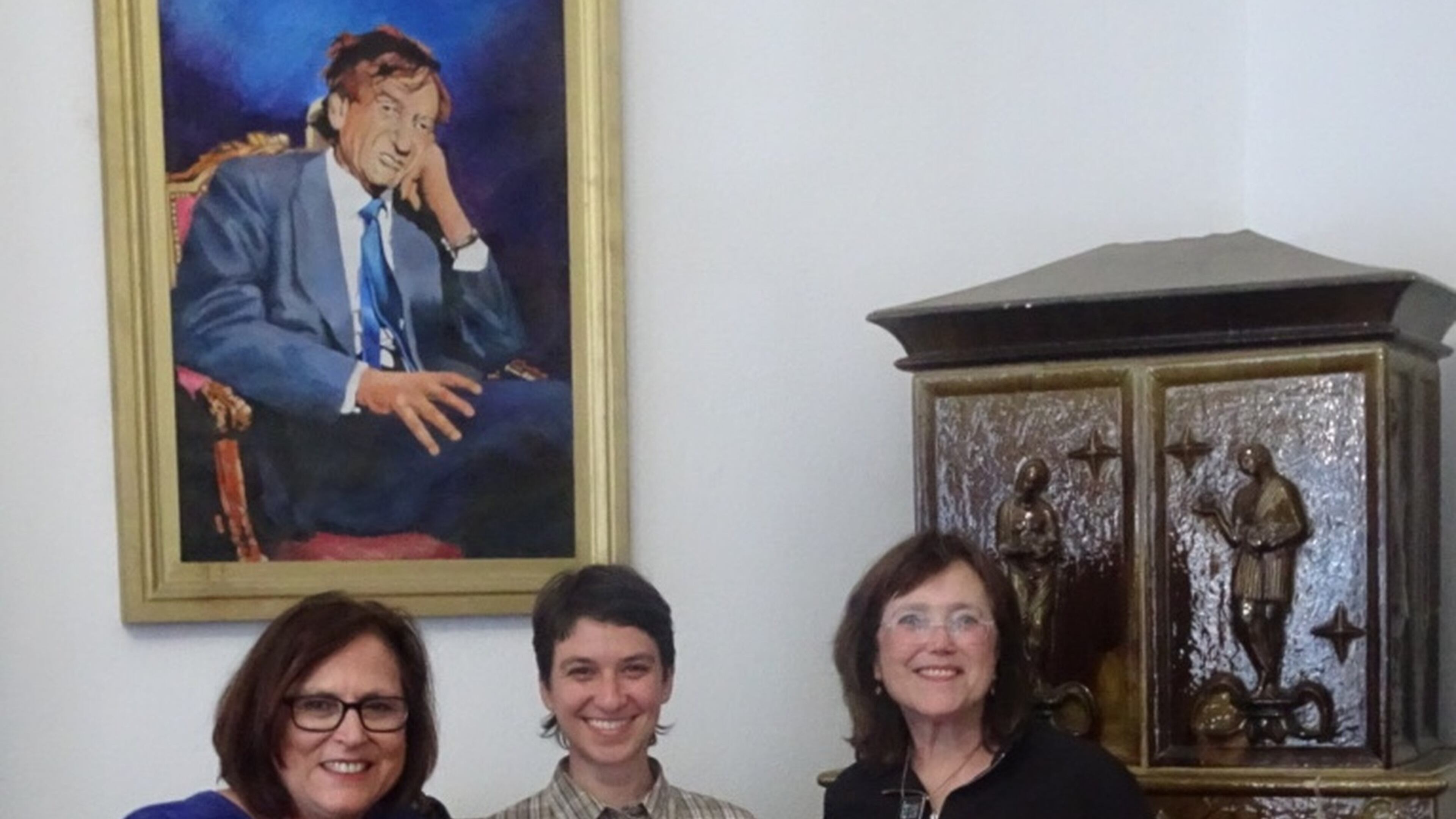 Freda Goodman (left) and her sister Helen Silberminz (right) pose beneath a portrait of Elie Wiesel with their tour guide at Wiesel’s childhood home in Sighet, Romania. The sisters traveled there in May to see their mother’s home located just minutes away from where the Nobel Peace Prize winner was born. Wiesel died Saturday at age 87. CONTRIBUTED PHOTO