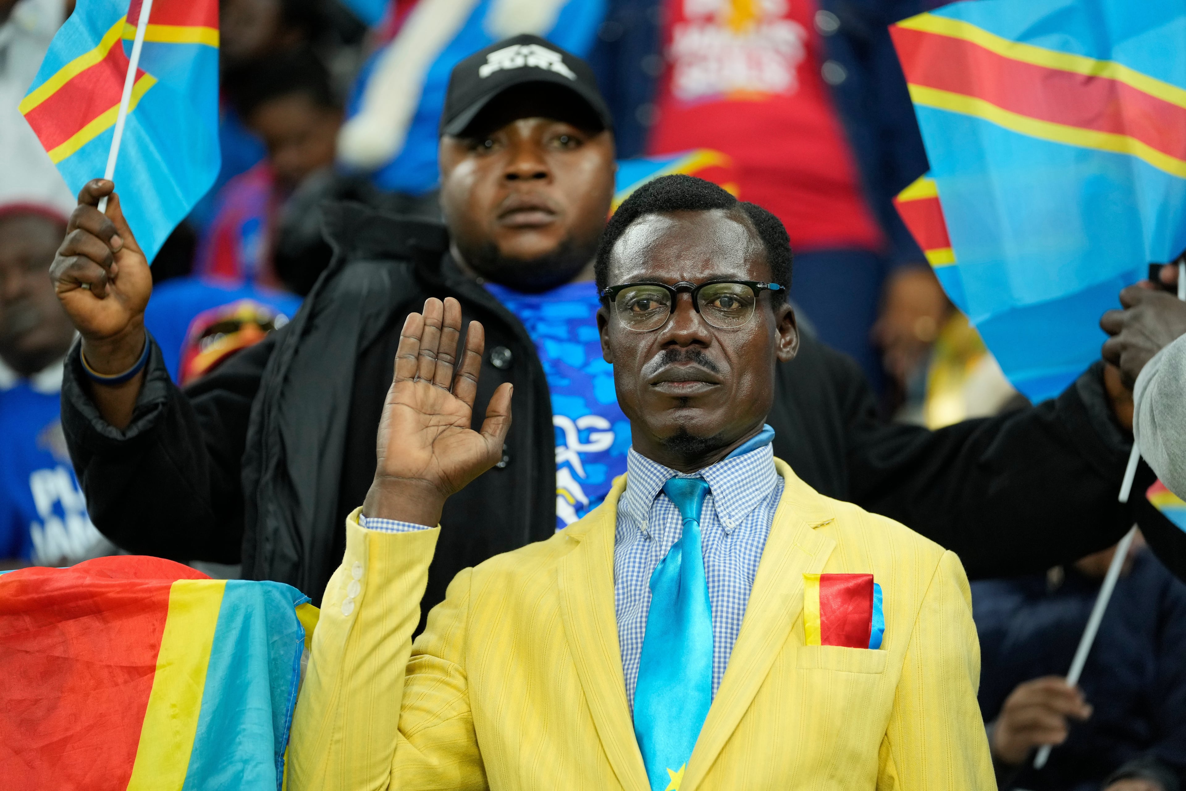 Michel Nkuka Mboladinga often impersonates the late Congolese leader Patrice Lumumba during DR Congo soccer games. He strikes the pose of Lumumba's memorial statue in Kinshasa. (Mosa'ab Elshamy/AP 2025)