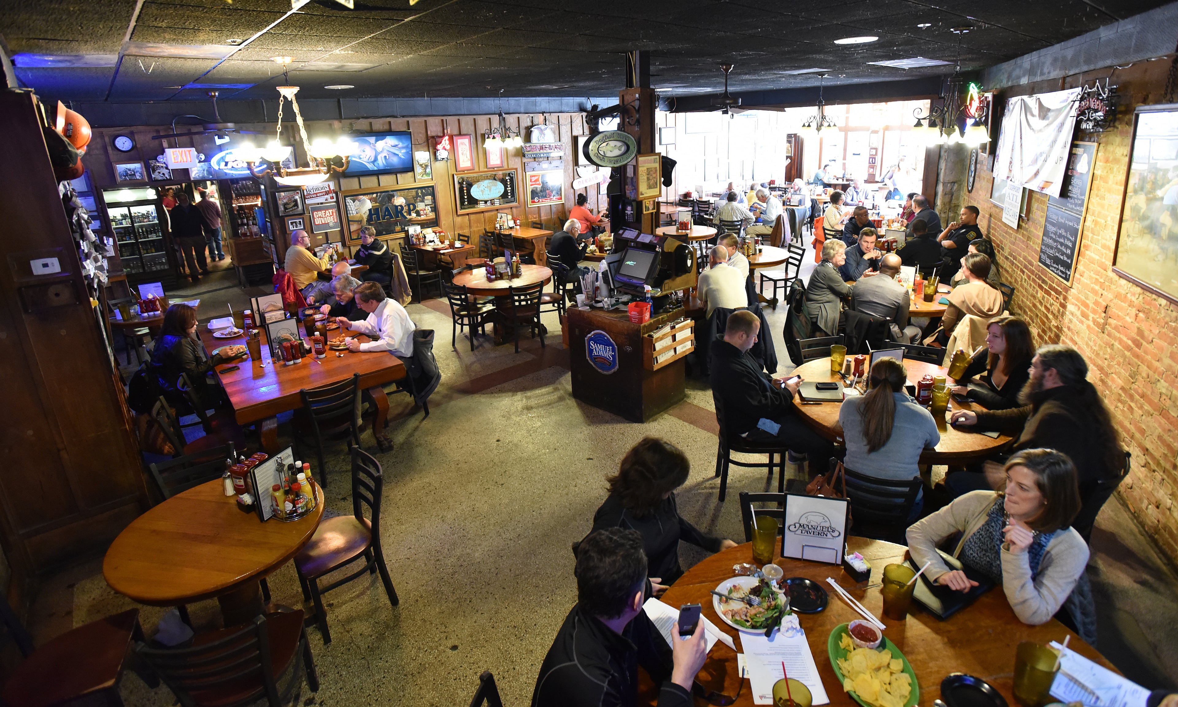 A packed crowd of lunch goers at Manuel's Tavern on Friday, February 27, 2015. Manuel's Tavern - the Poncey-Highland bar and decades-old haunt for politicos, reporters and regular in-towners - plans to close for extensive renovations that will coincide with construction of a large mixed-use development. It's a risky move for the storied tavern, closing to redo a classic dive, and hope the customers return. Will loop in why this is being done, the nearby development to come and the tavern's political history. HYOSUB SHIN / HSHIN@AJC.COM