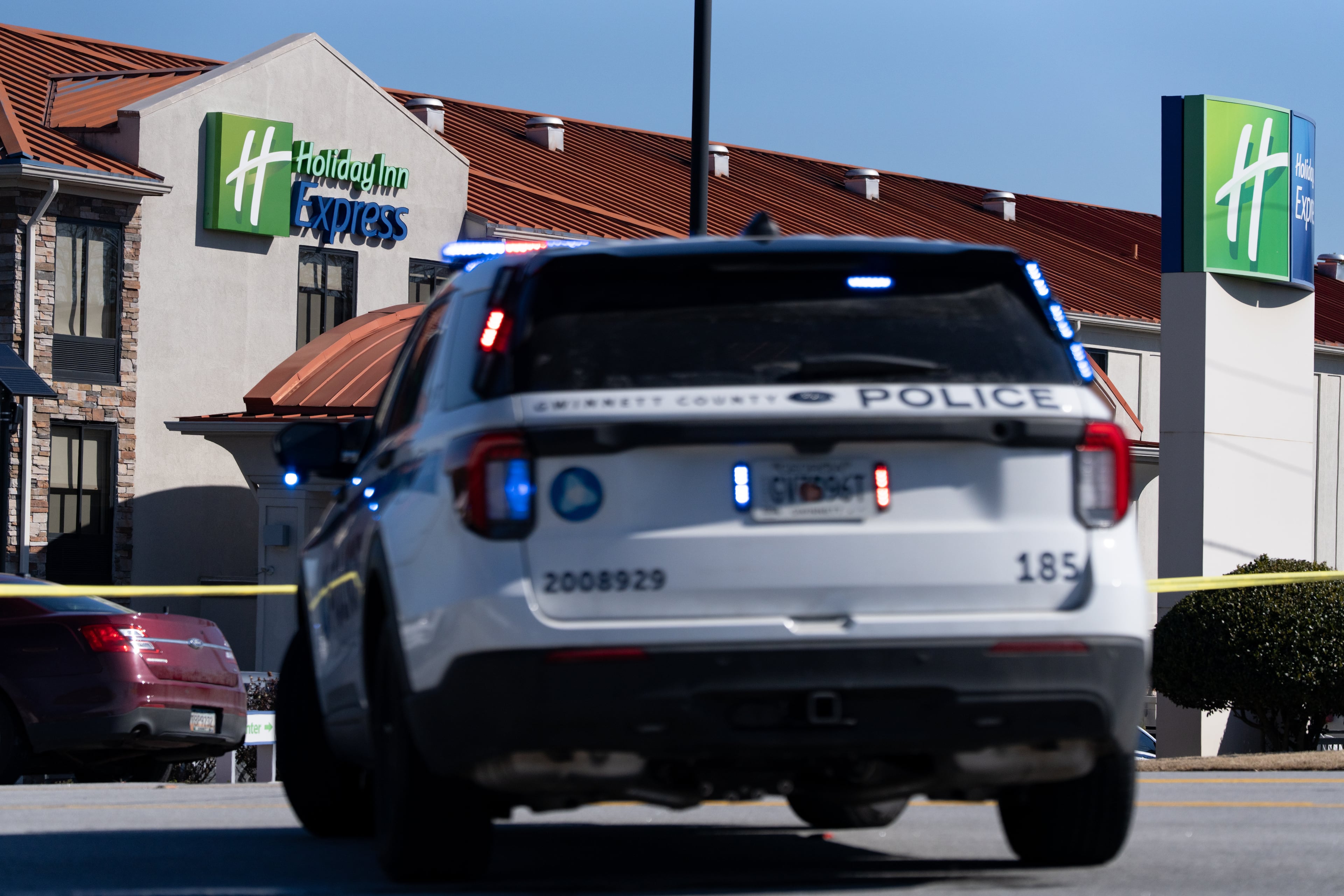 A Gwinnett County police vehicle sits at the scene of the officer-involved shooting at a Holiday Inn Express on East Park Place Boulevard near Stone Mountain on Sunday. (Ben Hendren for the AJC)