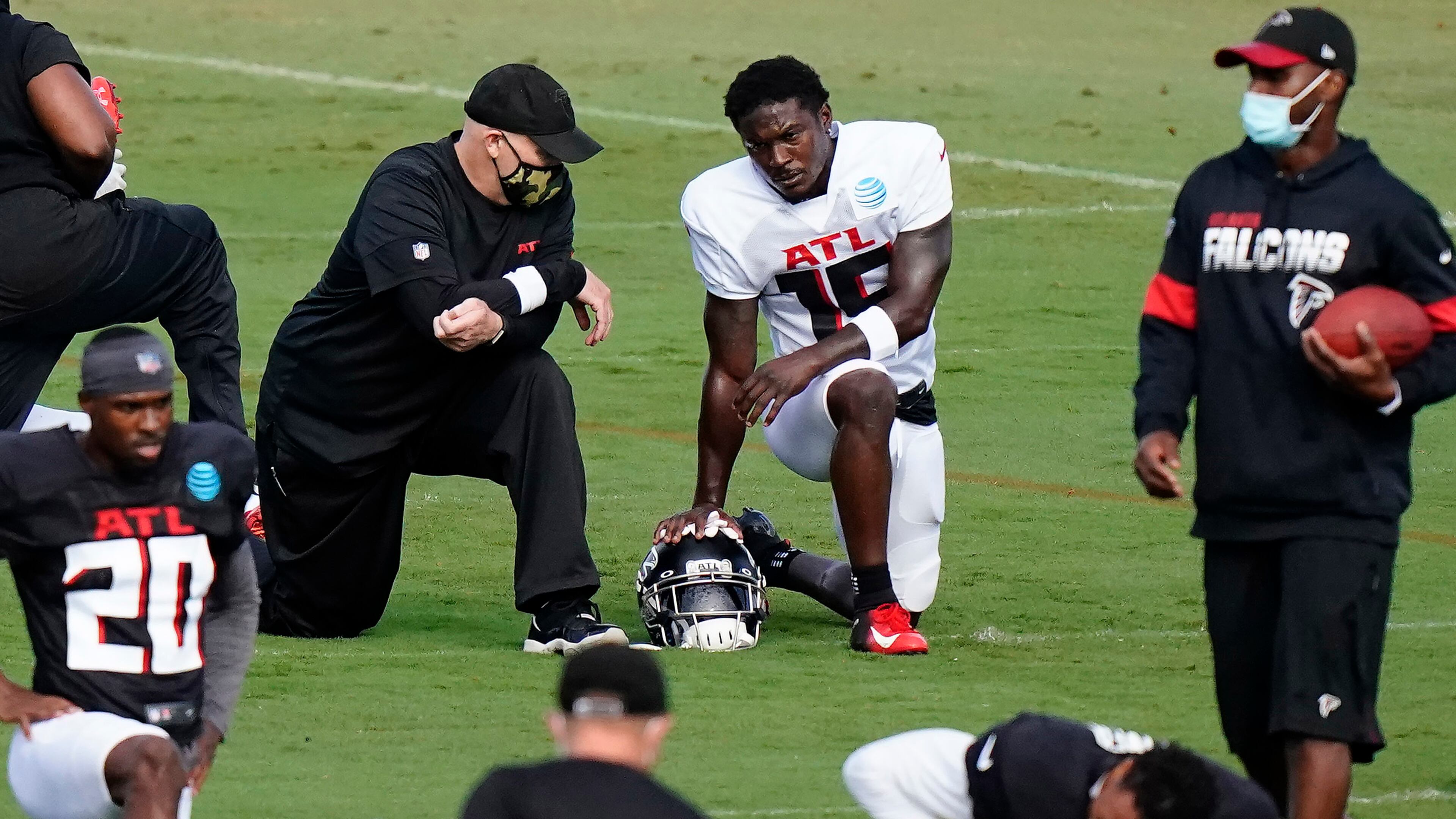 Coach Dan Quinn chats with receiver Brandon Powell during Wednesday's workout in Flowery Branch. (AP Photo/Brynn Anderson, Pool)