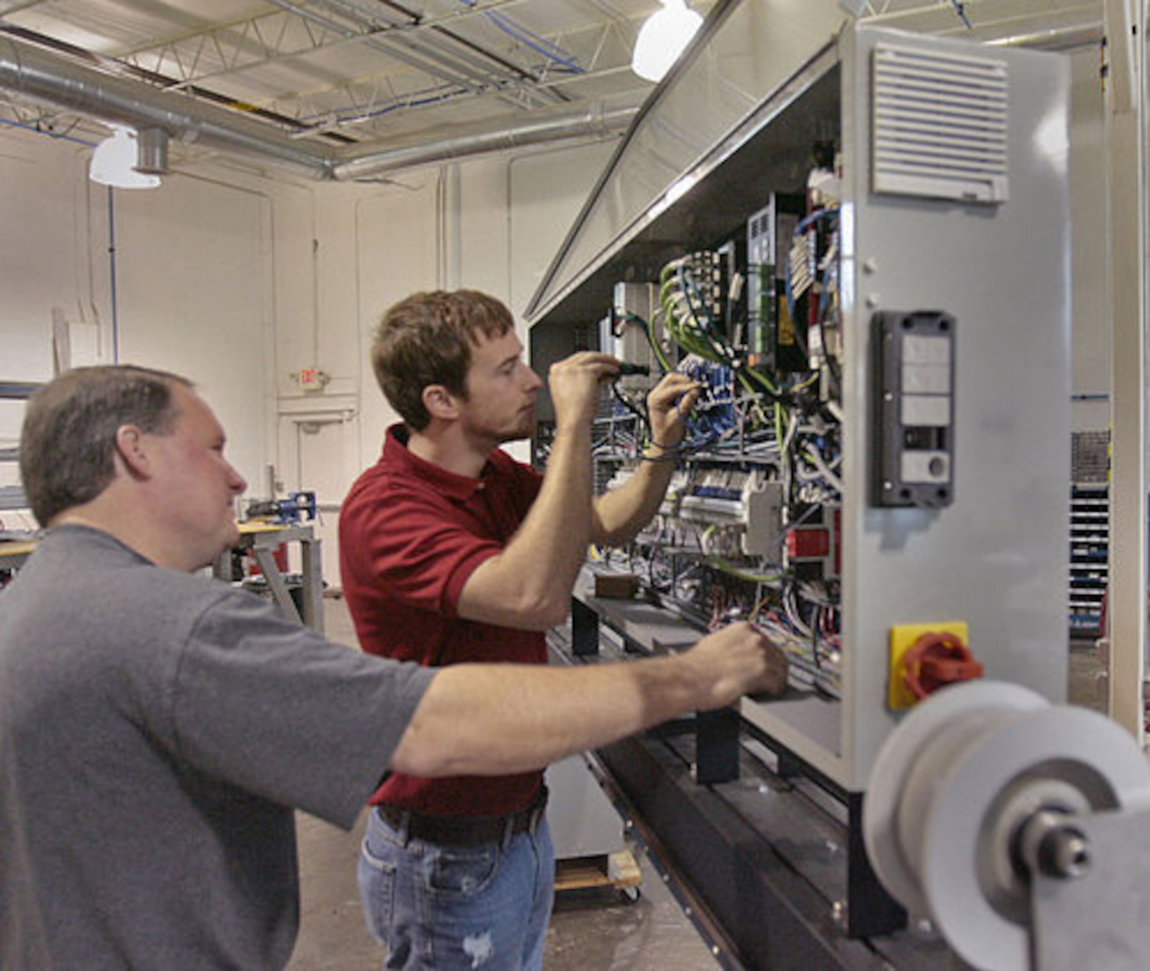 Pat Barber (left) and Chip Daymude work on upgrades for the CAMotion LDP100 robot.