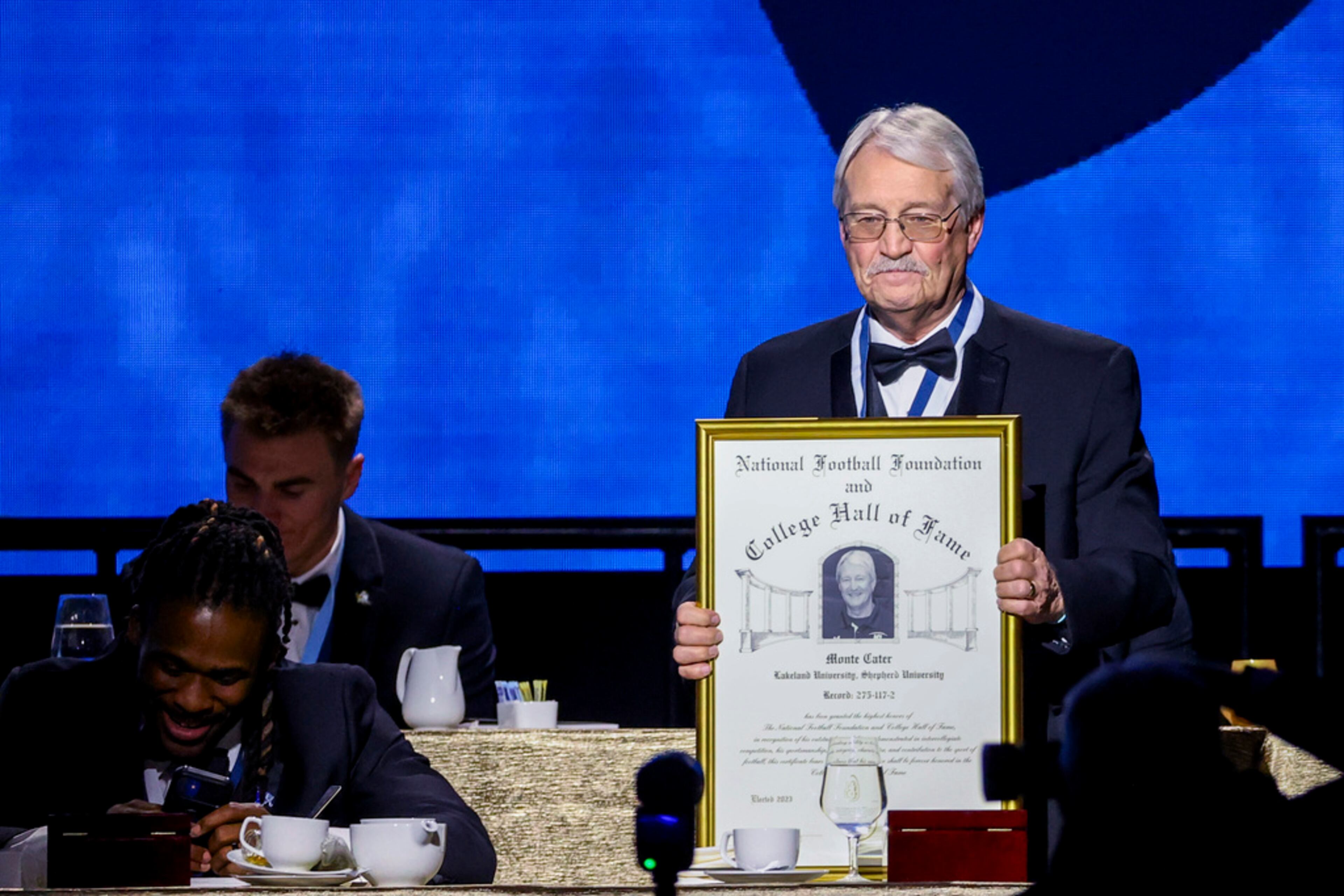Former Lakeland and Shepherd football coach Monte Cater holds up his College Football Hall of Fame Award during the National Football Foundation Awards Dinner, Tuesday, Dec. 5, 2023, in Las Vegas. (AP Photo/Ian Maule)